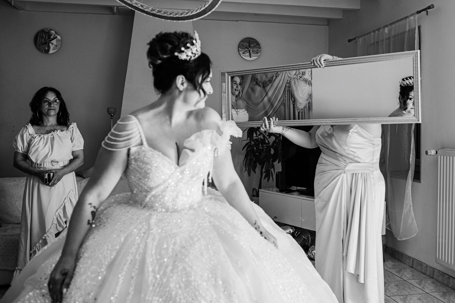 A series of black and white photos showing wedding dress preparations and bridal moments in a dressing room.
