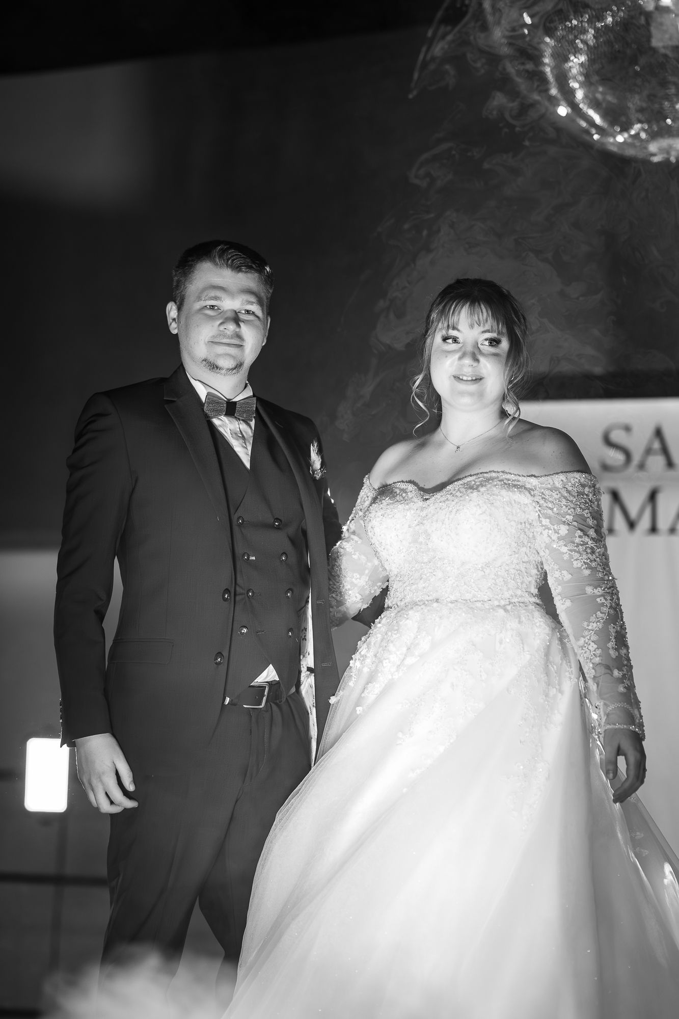 A black and white wedding photo series showing a couple in formal attire dancing and posing together.