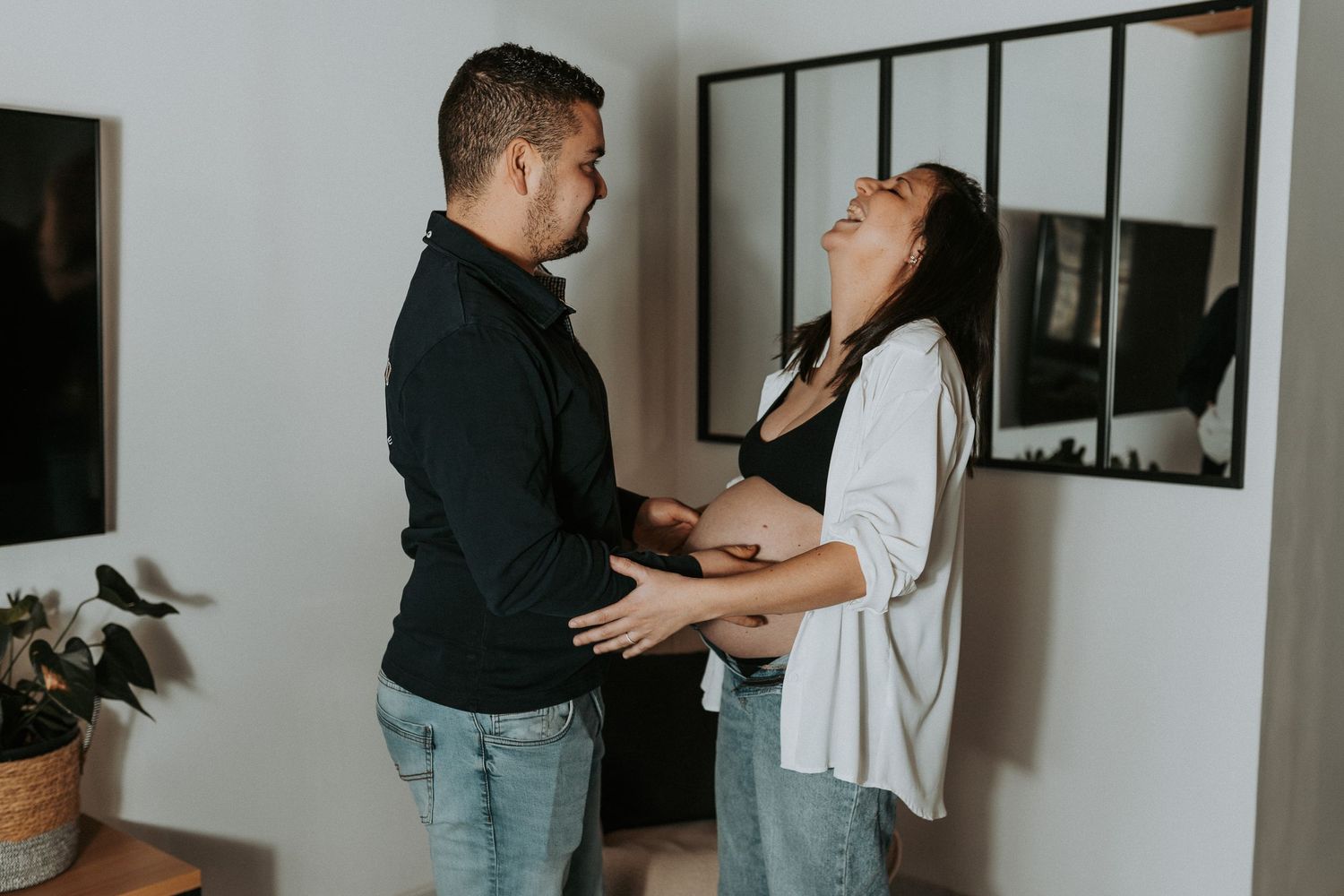A couple shares tender moments in a photo series showing affectionate poses against a neutral wall.