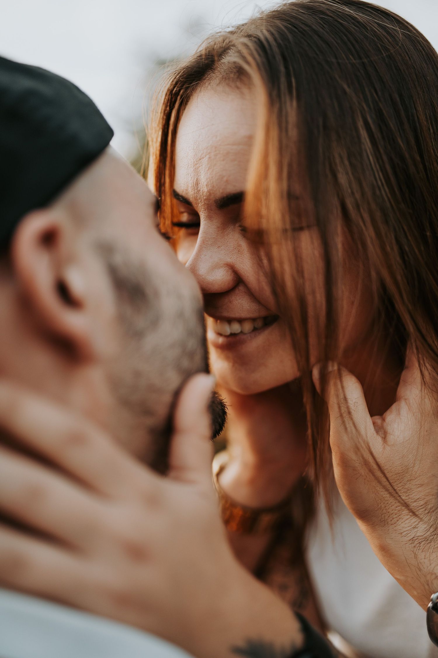 Close up intimate portrait of a romantic couple sharing a tender moment together in warm lighting.