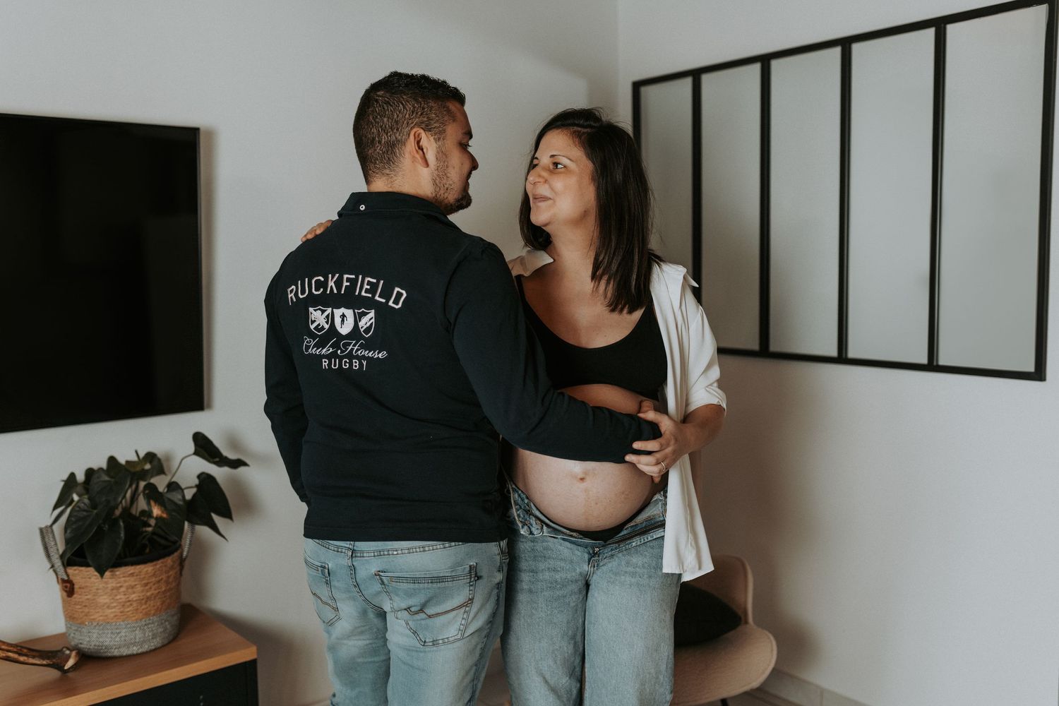 A couple shares intimate moments in a photo collage showing them laughing and embracing in a modern indoor setting.