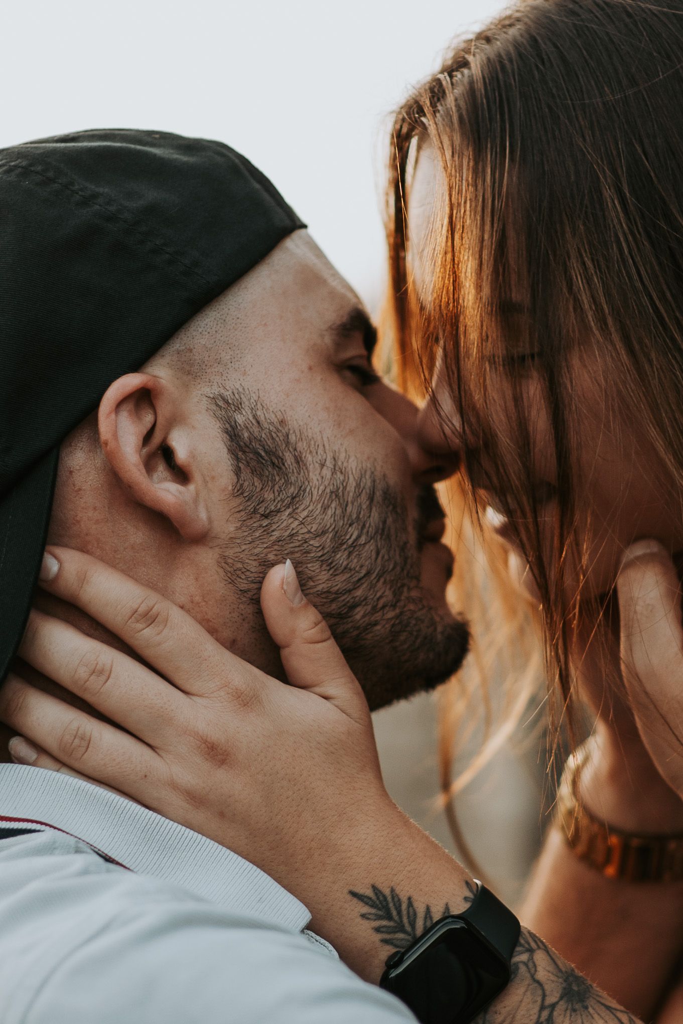 Intimate close-up of a couple sharing a tender kiss in soft lighting.