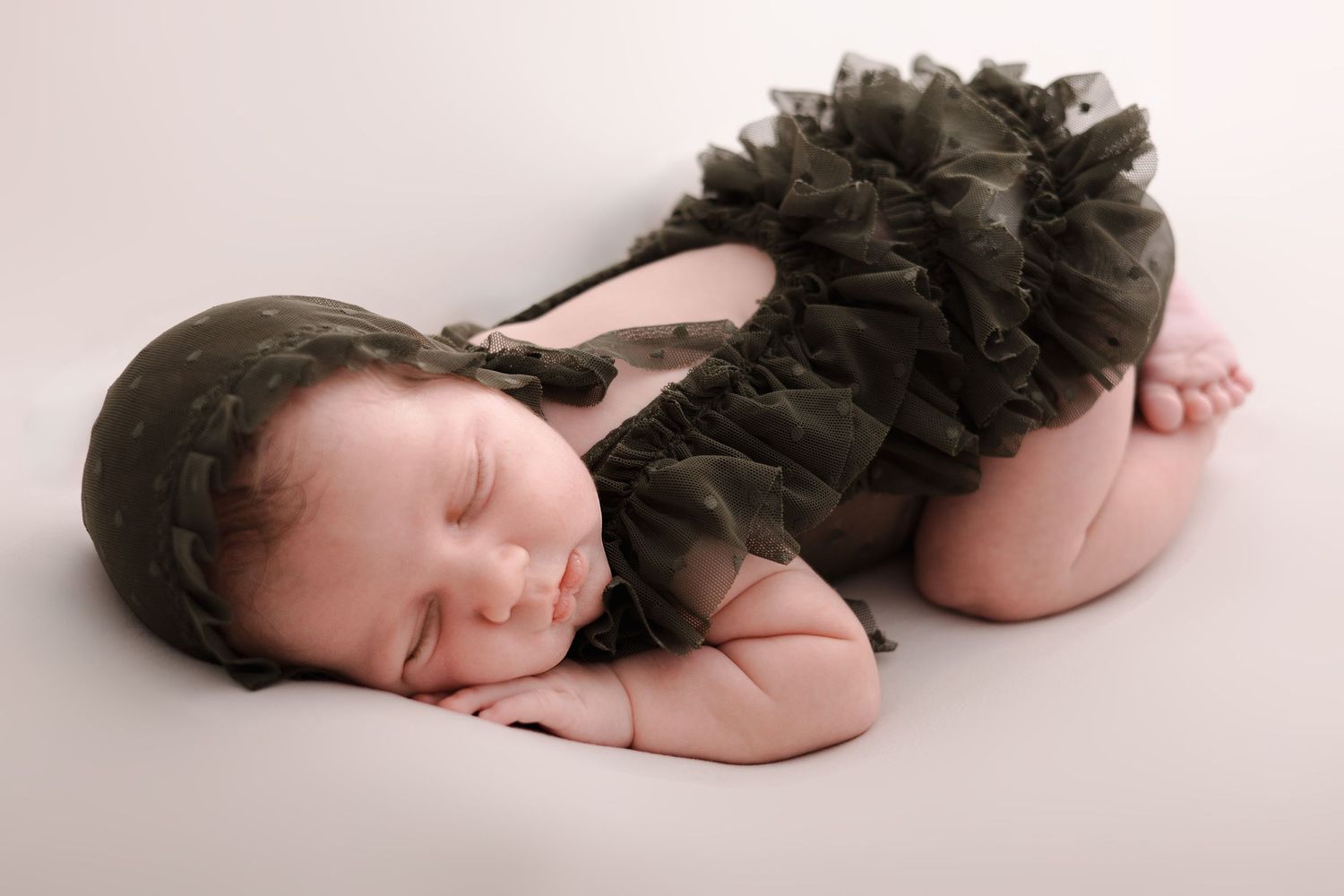 Newborn baby peacefully sleeping on a soft beige blanket in a sequence of artistic portraits.