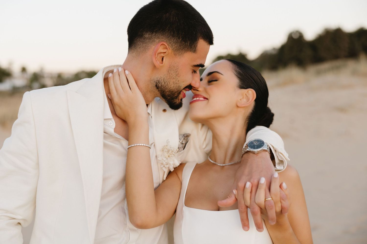 Wedding couple sharing a tender moment on the beach of Ferragudo, Portugal