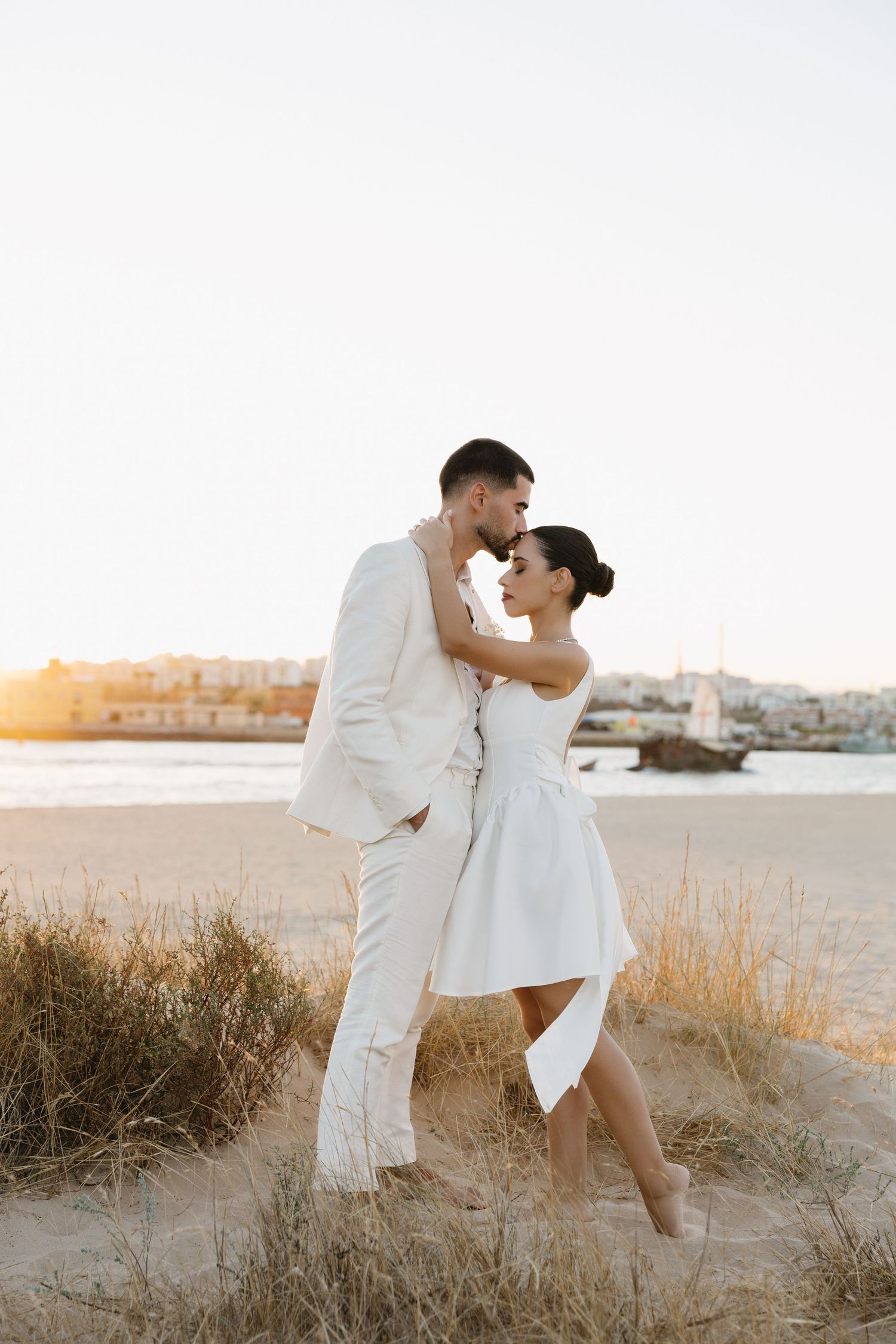 bridal couple standing in the sand together during the sunset at praia da angrinha, Algarve
