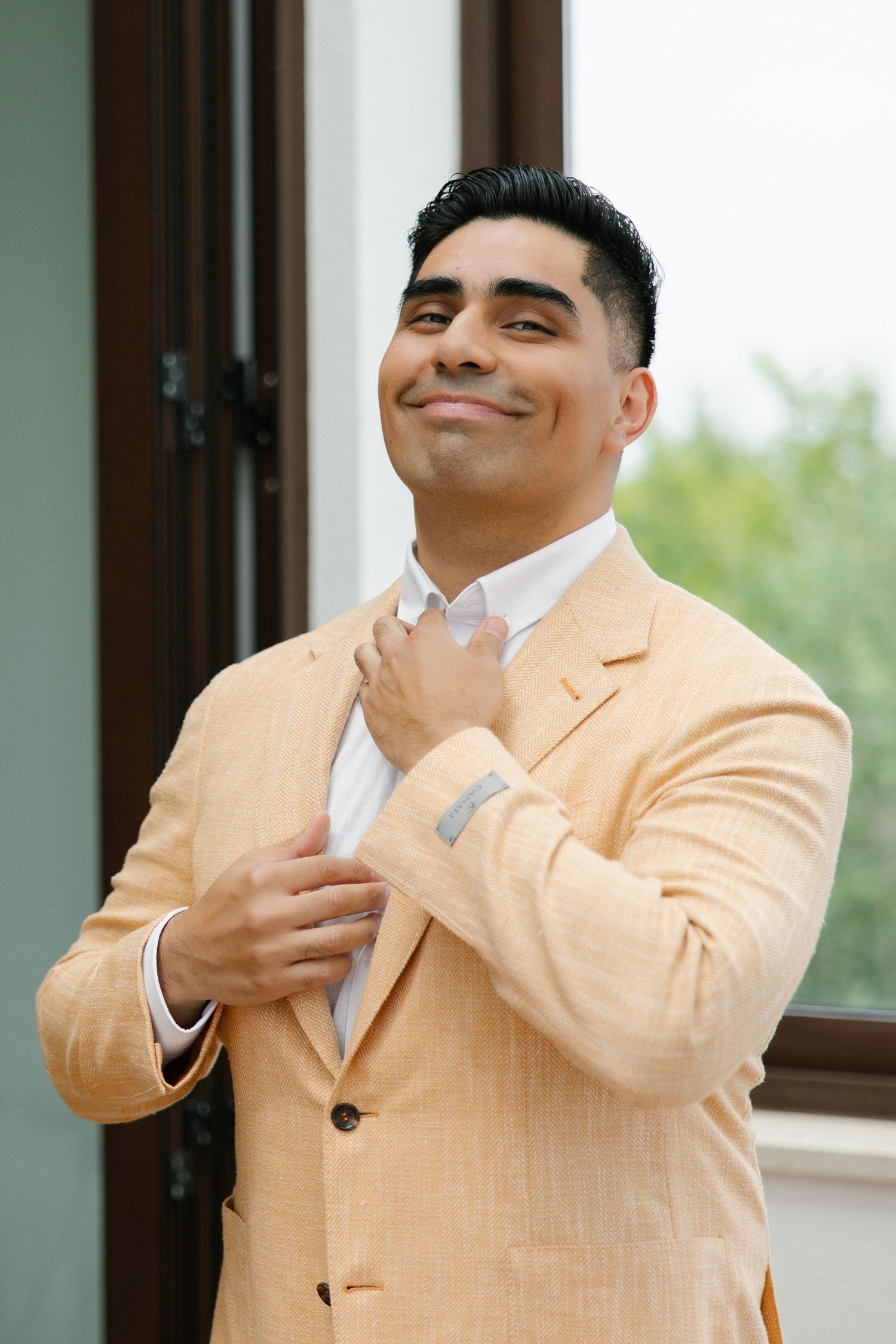 Groom adjusting his tie during a wedding in Portugal