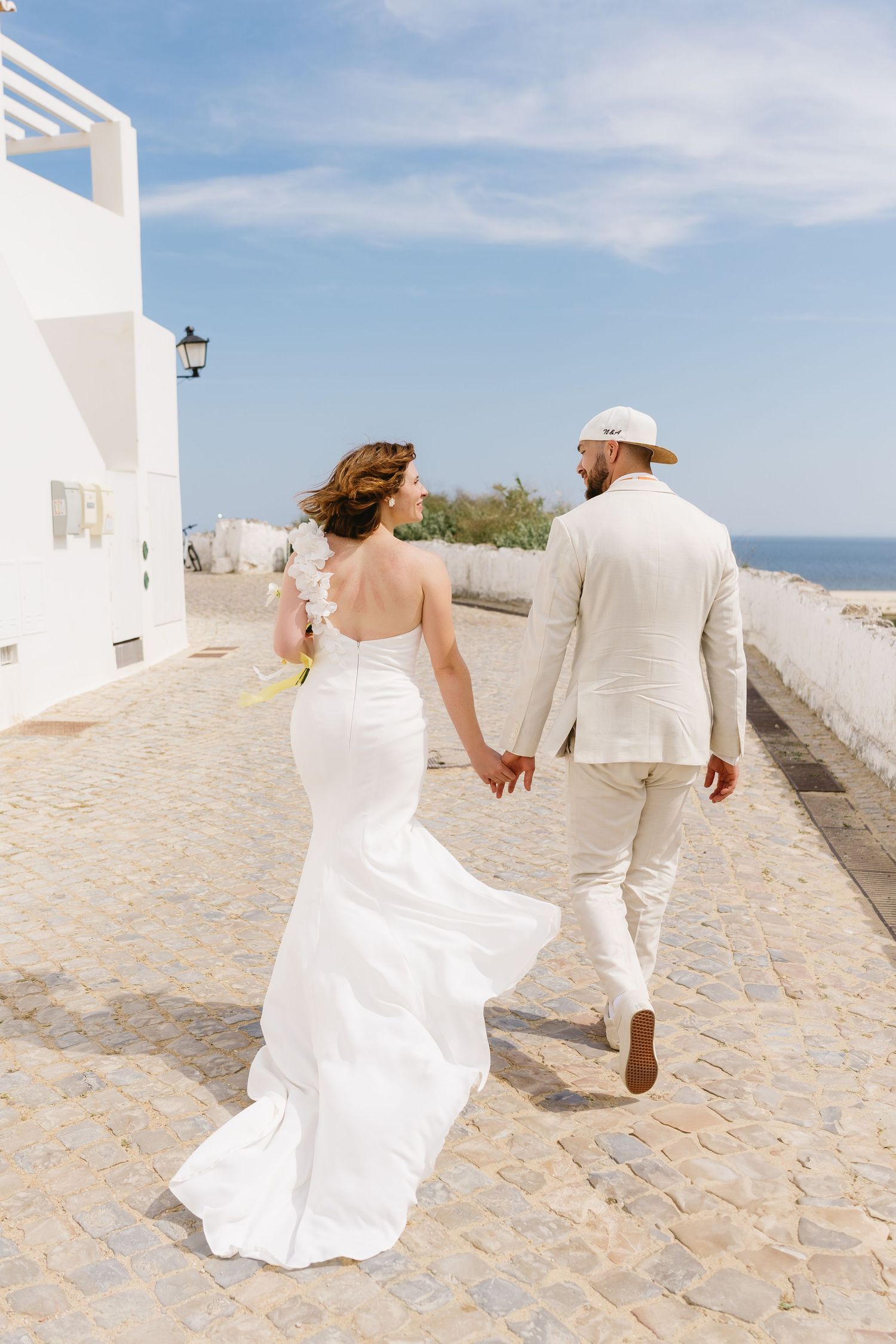 Nikola and Albrecht walking together at a rustic town next to ocean of Tavira