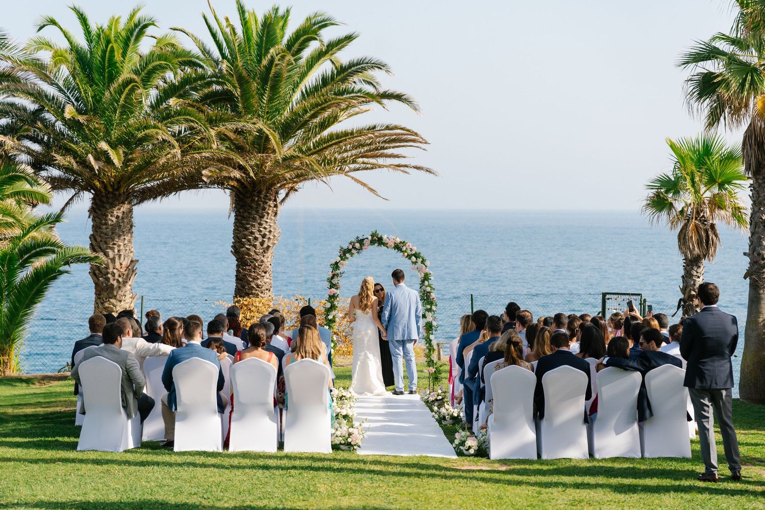 Wedding ceremony with ocean view surrounded by cliffs and palmtrees at the pestana viking resort in the algarve