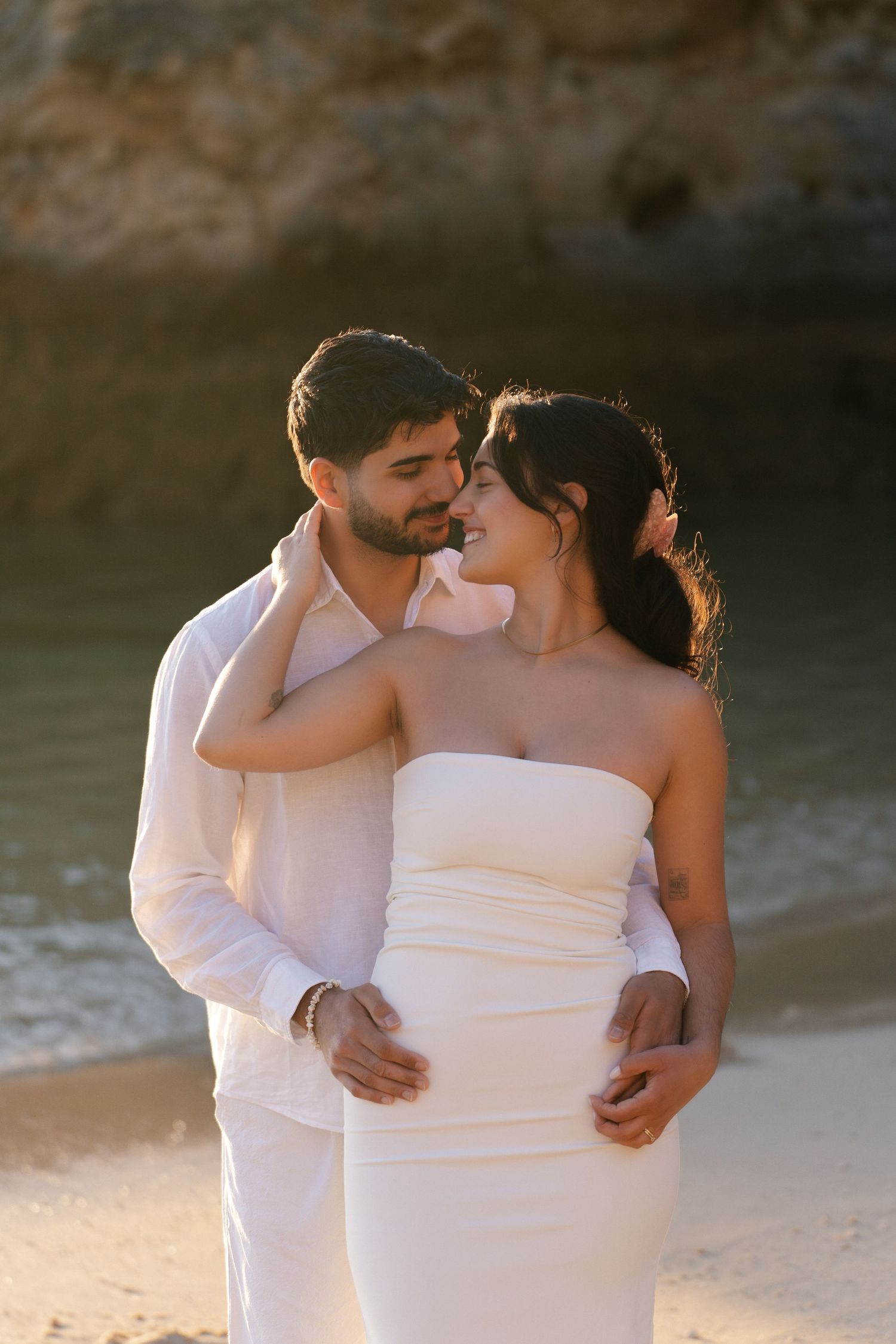 Romantic wedding couple hugging on the shores of Camilo Beach Algarve during golden hour