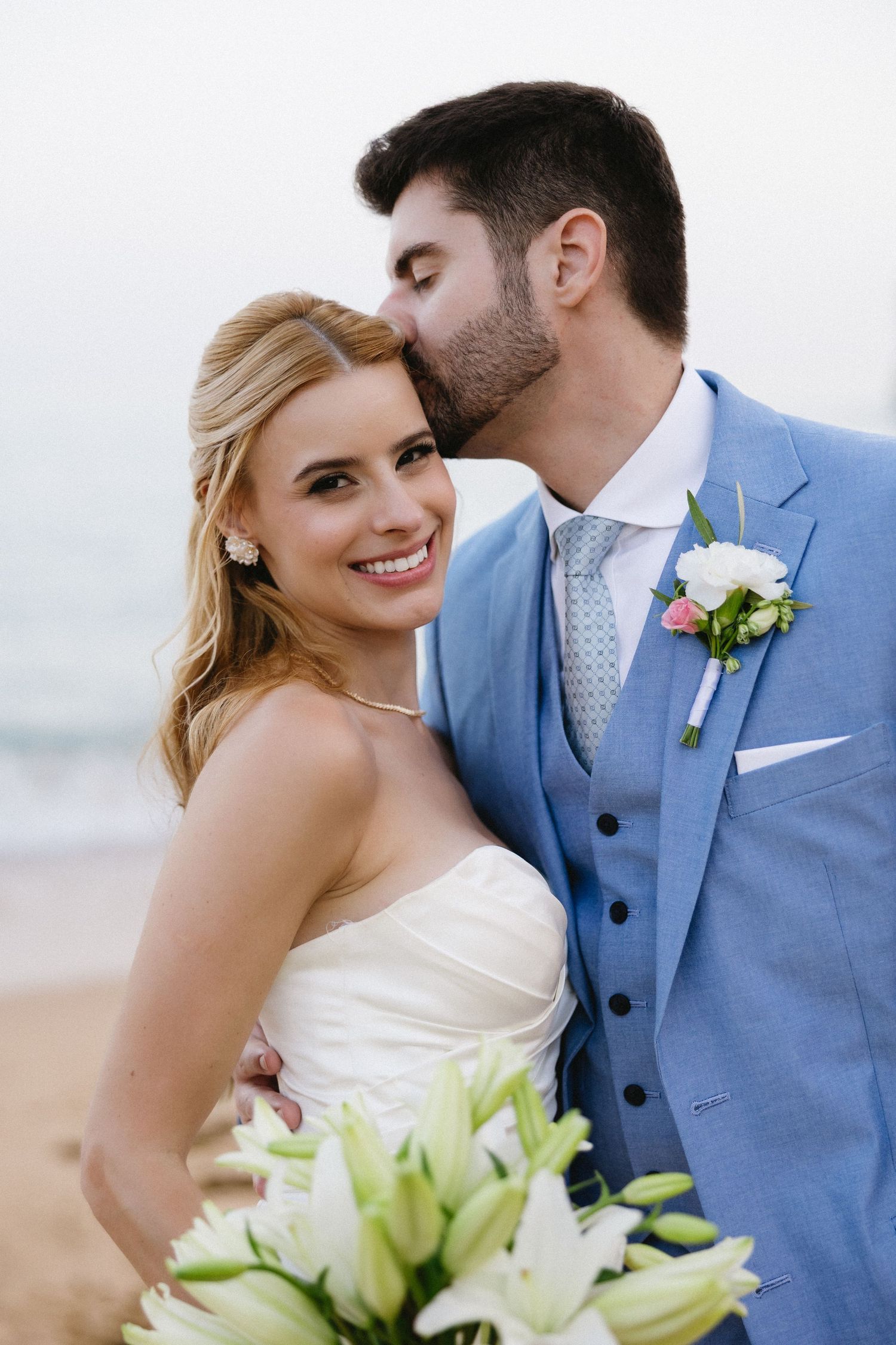 Groom giving the bride a kiss on the head