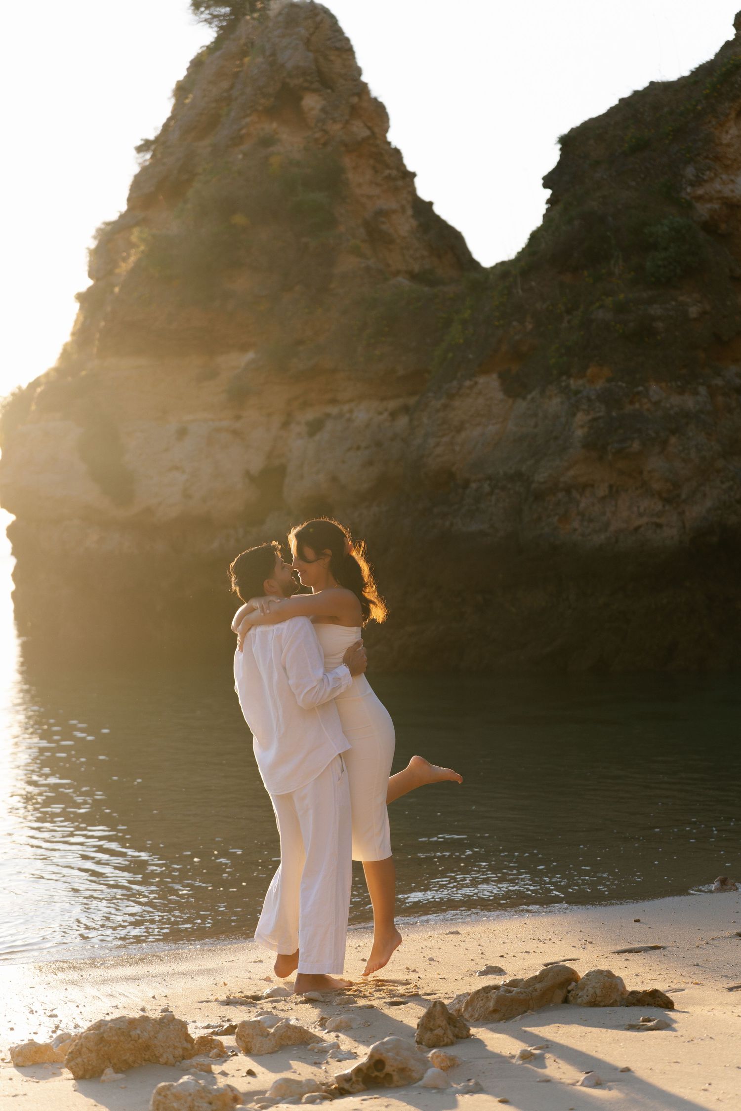 Wedding couple celebrating as the groom lifts up the bride on Camilo Beach Algarve