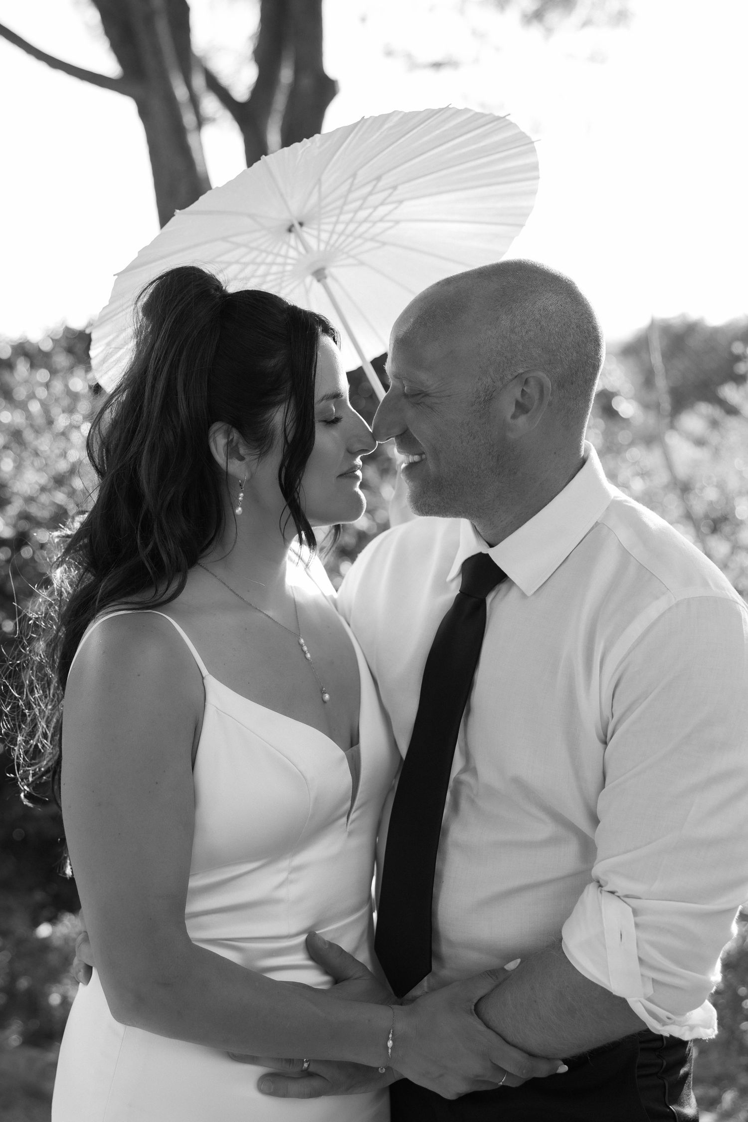 Wedding couple having an intimate moment under an umbrella during their wedding at nossa senhora, algarve