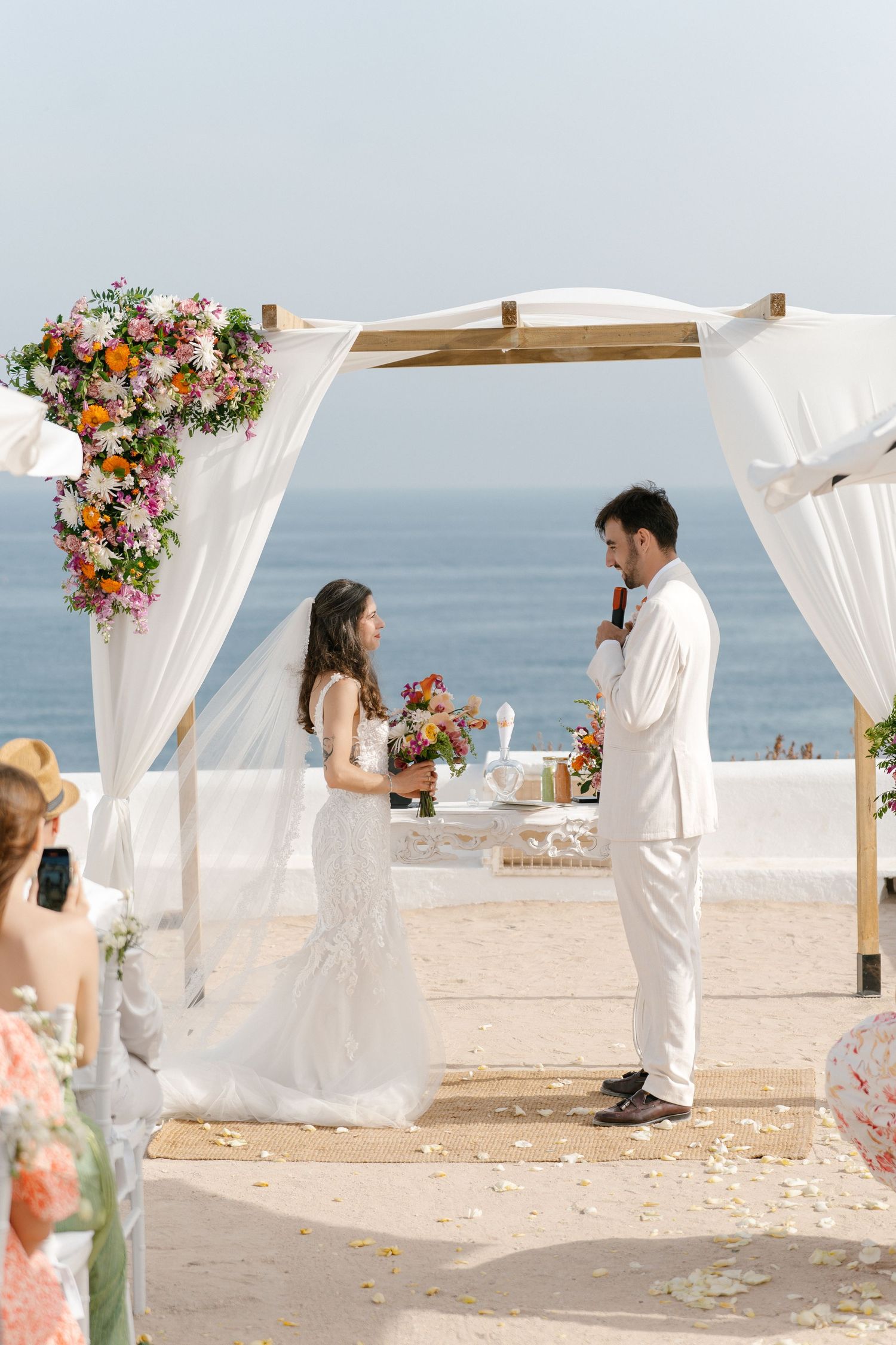 Wedding couple standing on the aisle of the lady of the rock telling there vows, while a wedding photographer in the algarve shoot it
