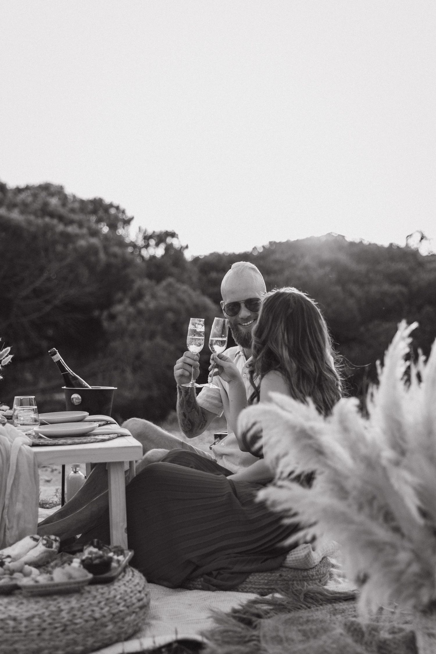Engaged couple enjoying a romantic picnic at sunset in the Algarve, Portugal