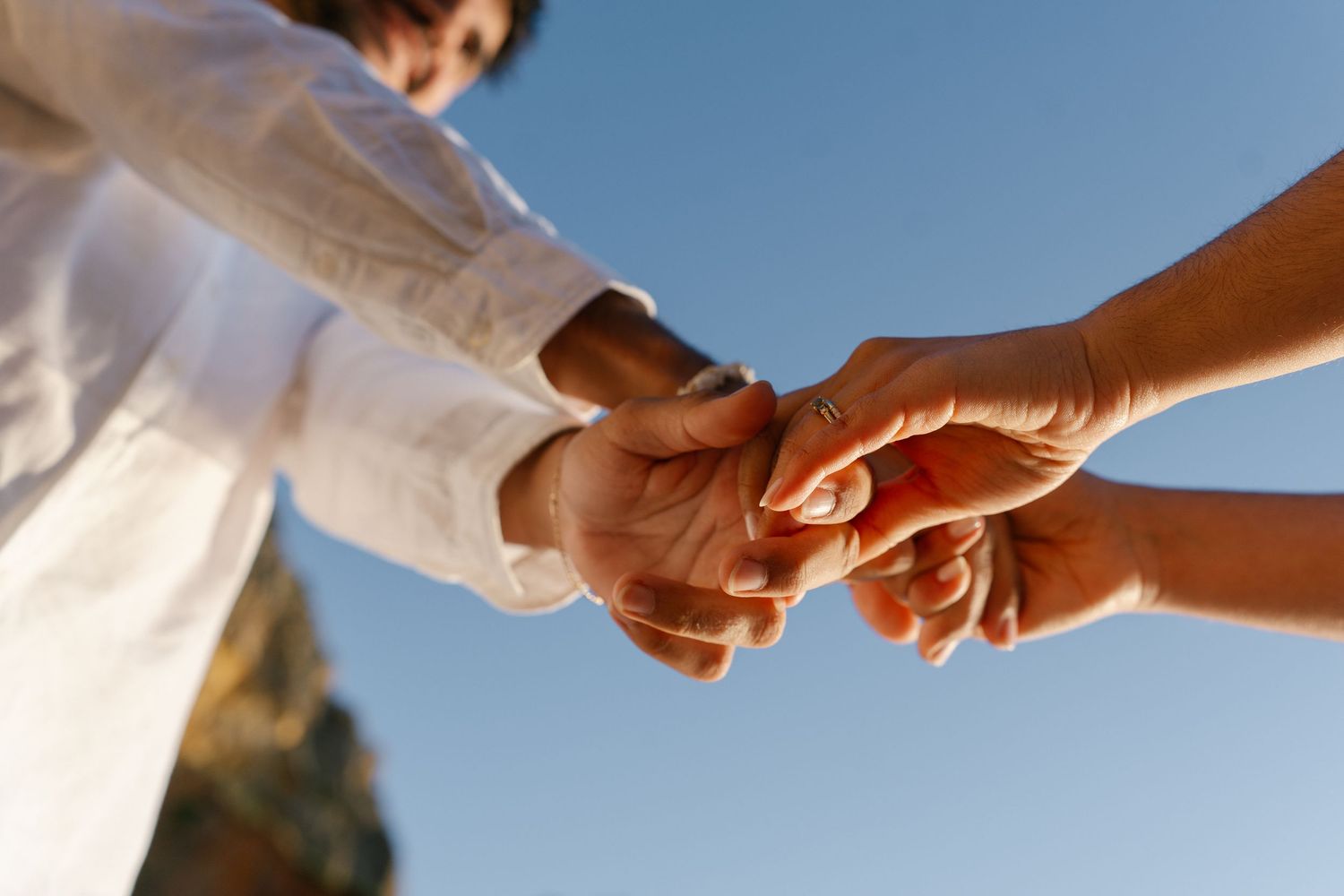 Couple holding hands with fingers woven together capturing a tender moment