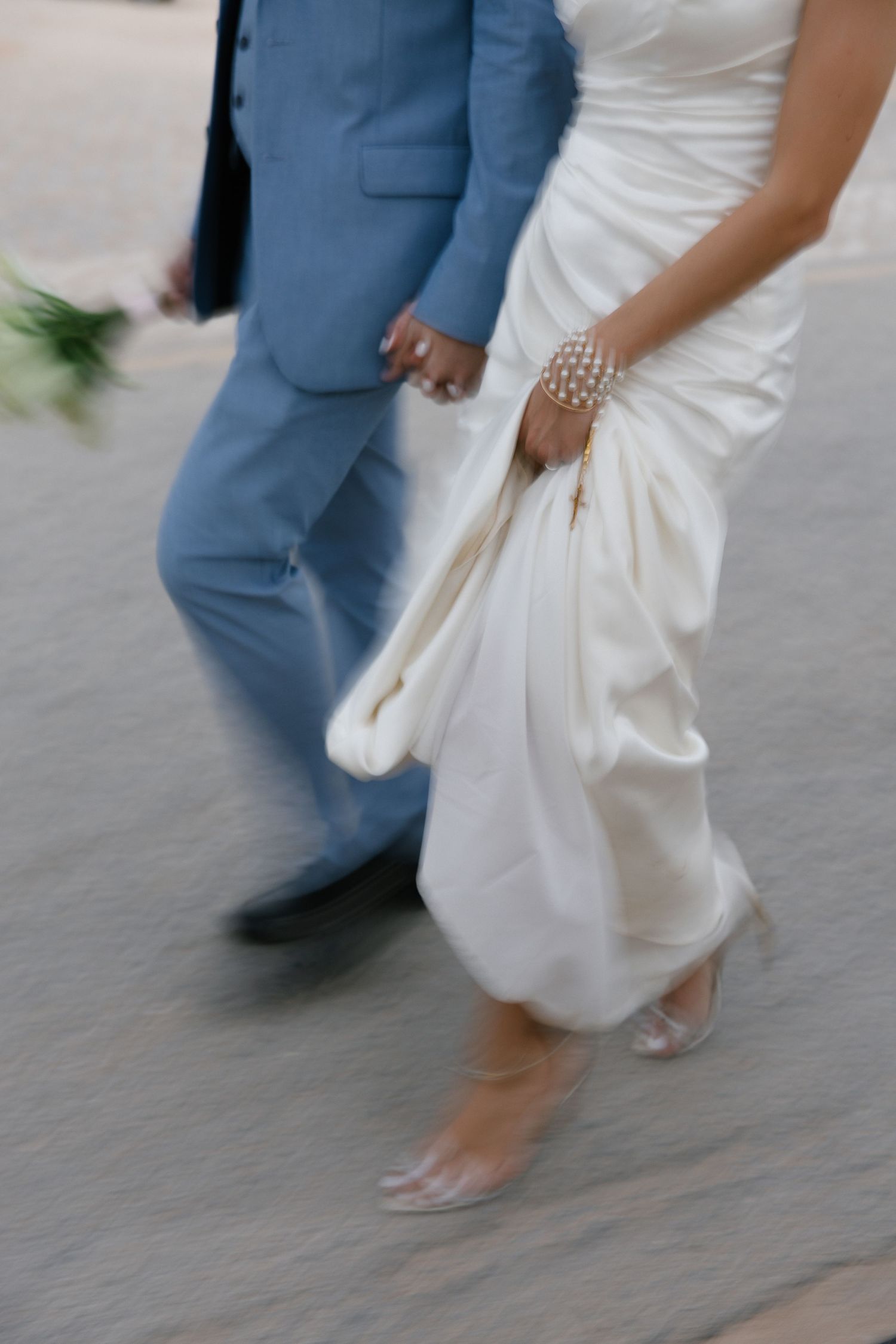 the legs and feet of bridal couple walking