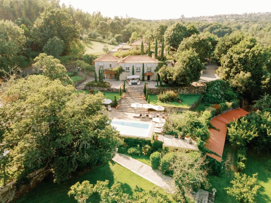 Aerial view of a luxurious Tuscan villa with pool surrounded by lush gardens.
