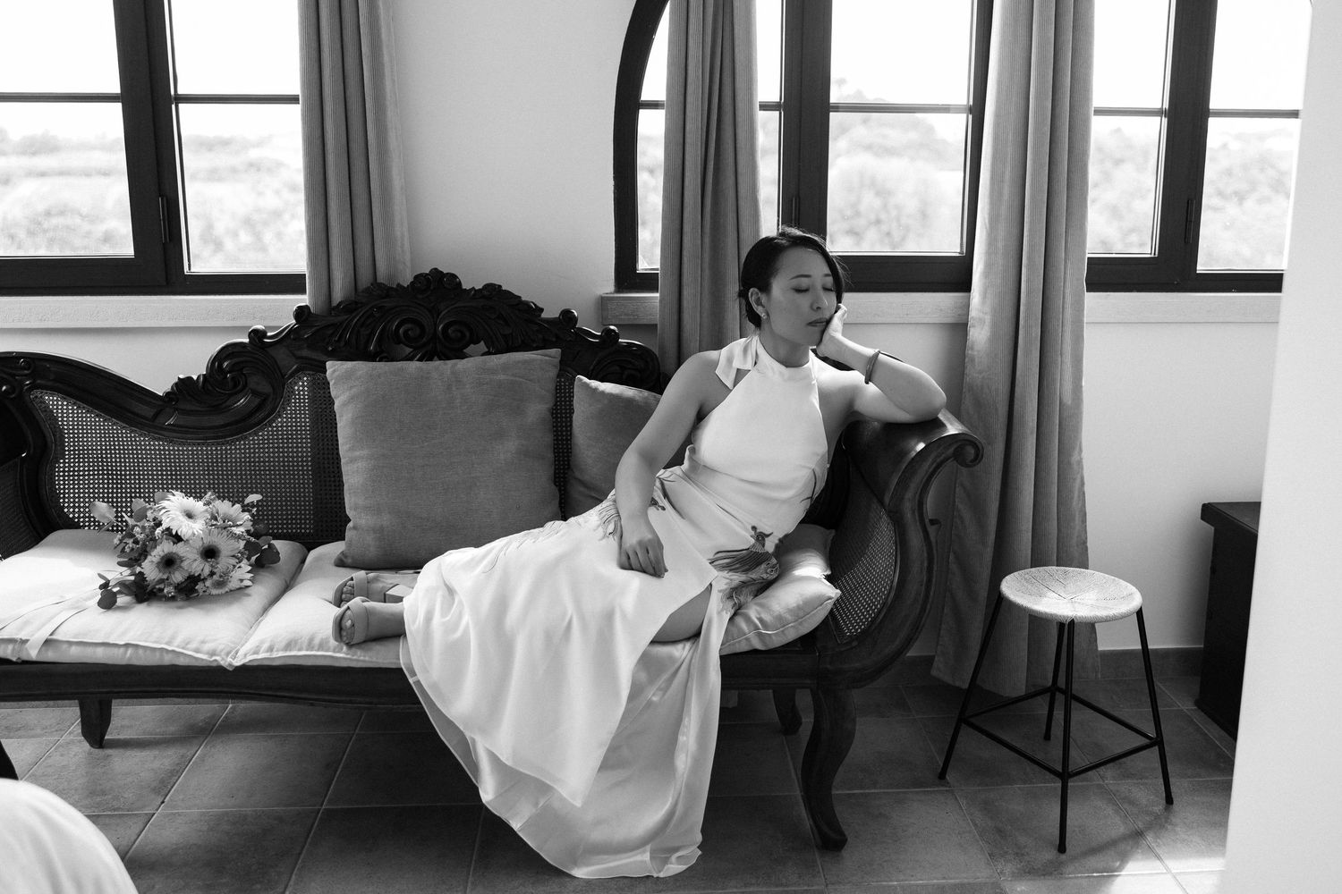 Artistic wedding photo of bride posing elegantly on a sofa