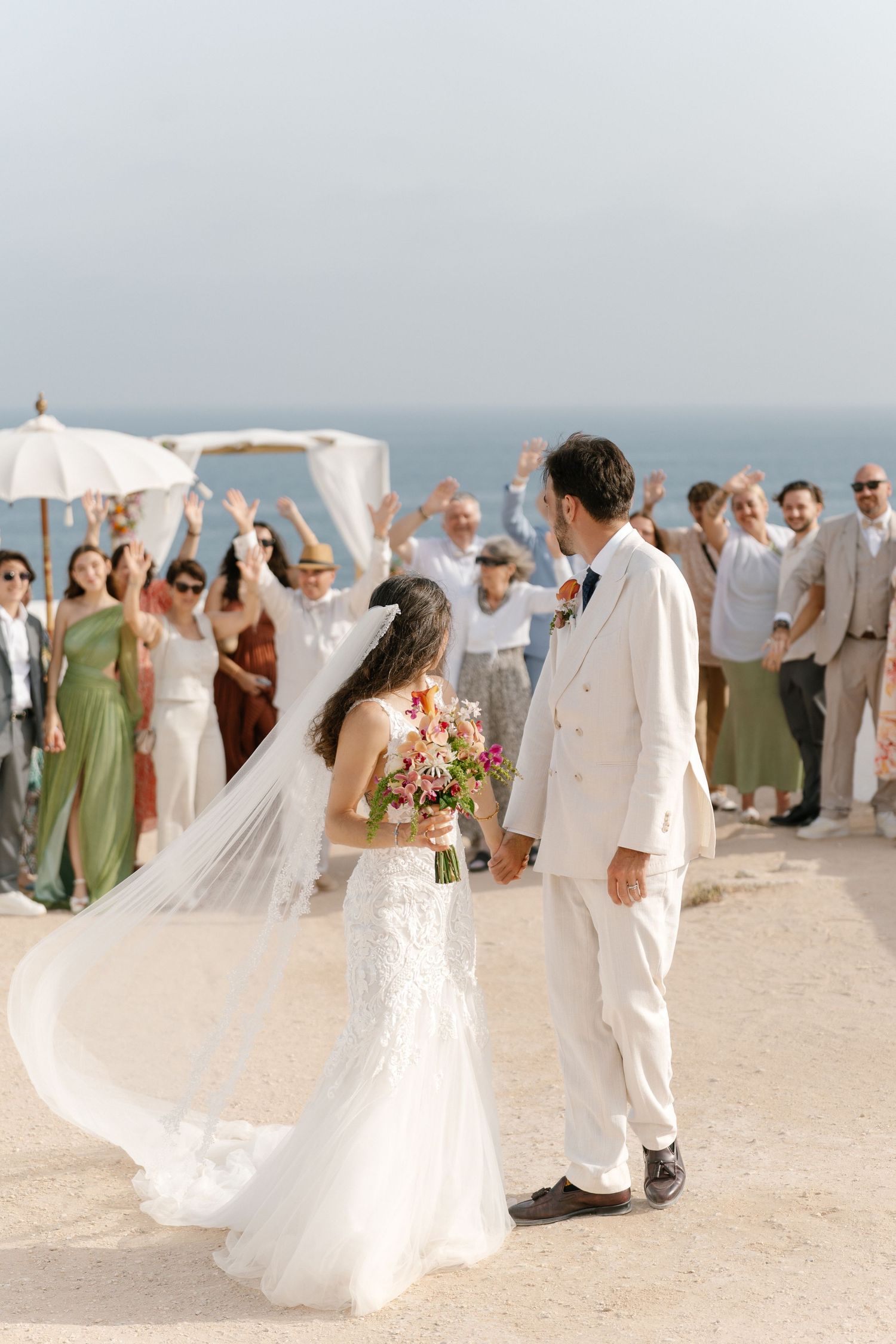 Joyful moment with guests cheering as the bride and groom walk together after saying “I do”