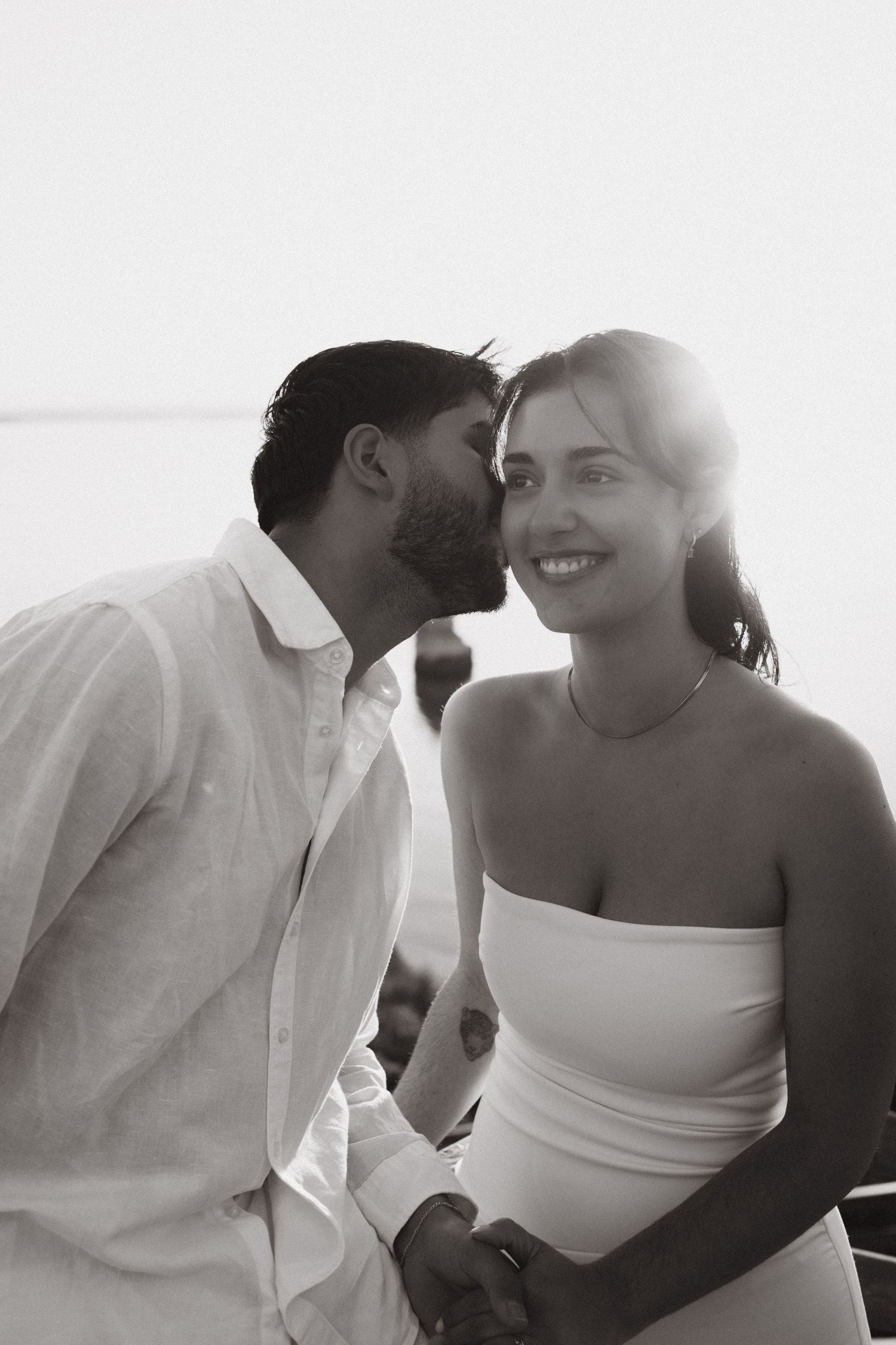 Wedding couple sharing a tender moment with the groom whispering in the bride’s ear