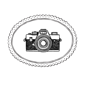 Vintage retro camera illustration inside an oval scalloped border frame, black and white ink stamp style design.