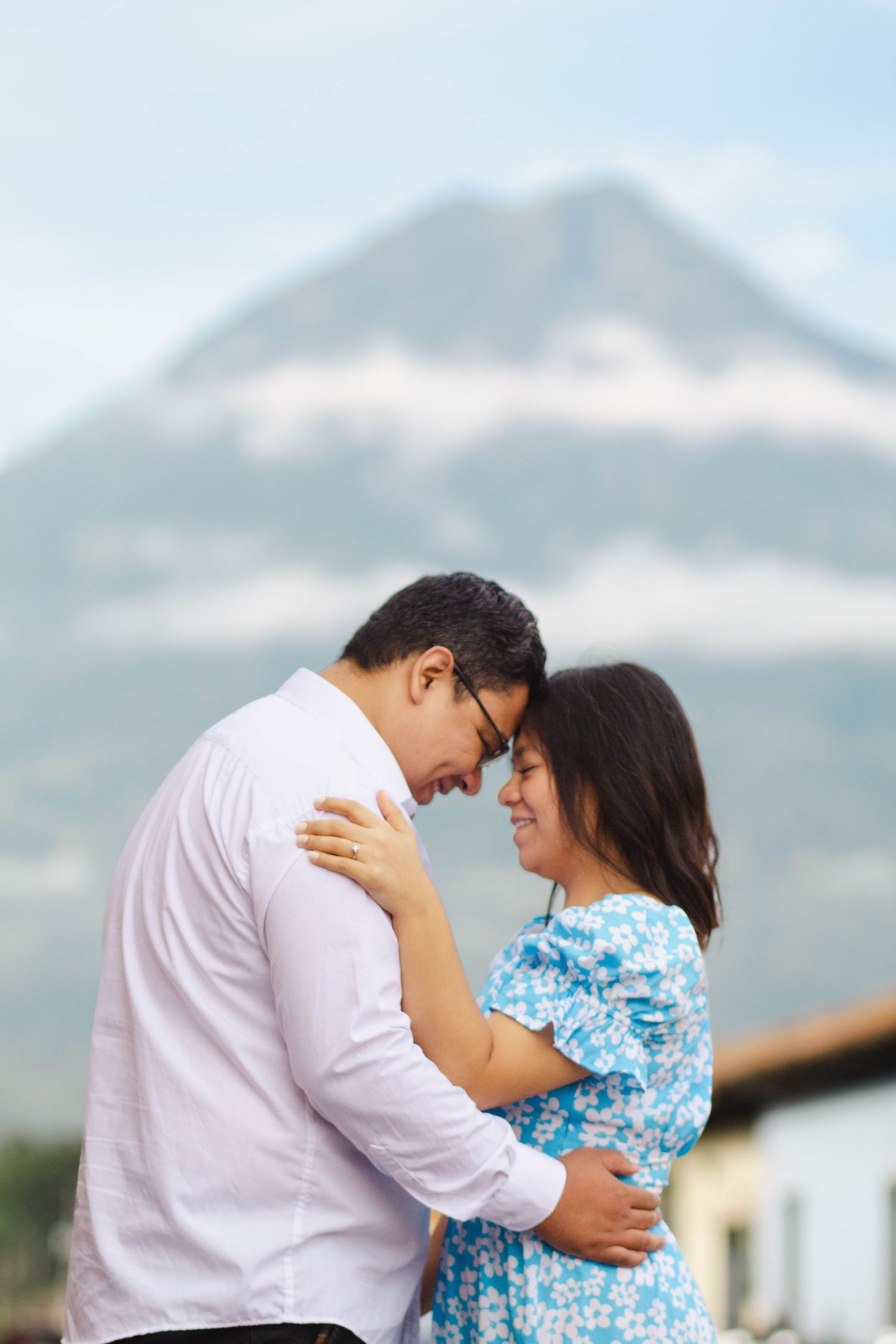 Intimate moment between couple with majestic volcano mountain in background.