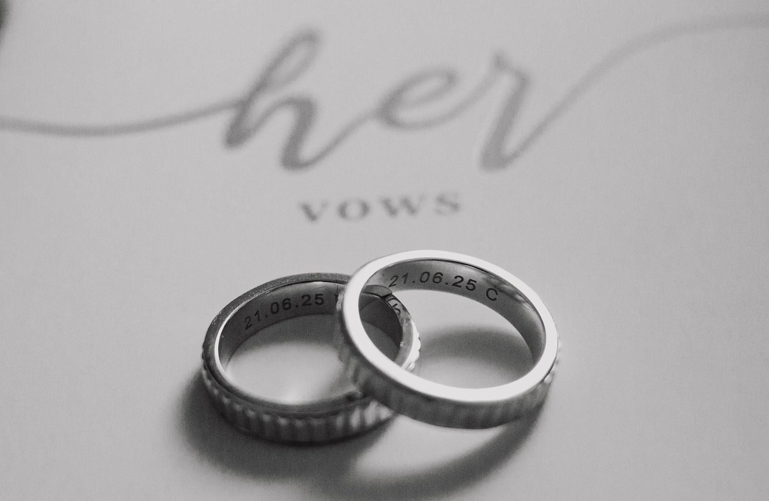 A row of silver and diamond wedding rings photographed in black and white close-up showing fine jewelry details.