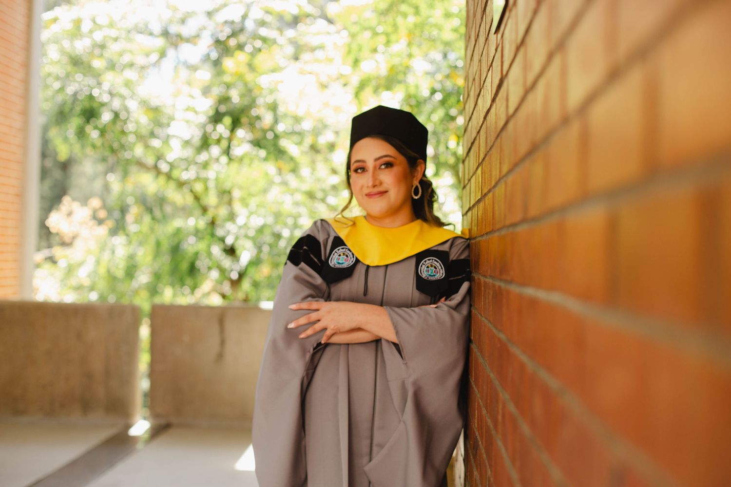 Woman in traditional Indian attire poses gracefully against a warm-toned architectural backdrop with natural lighting.