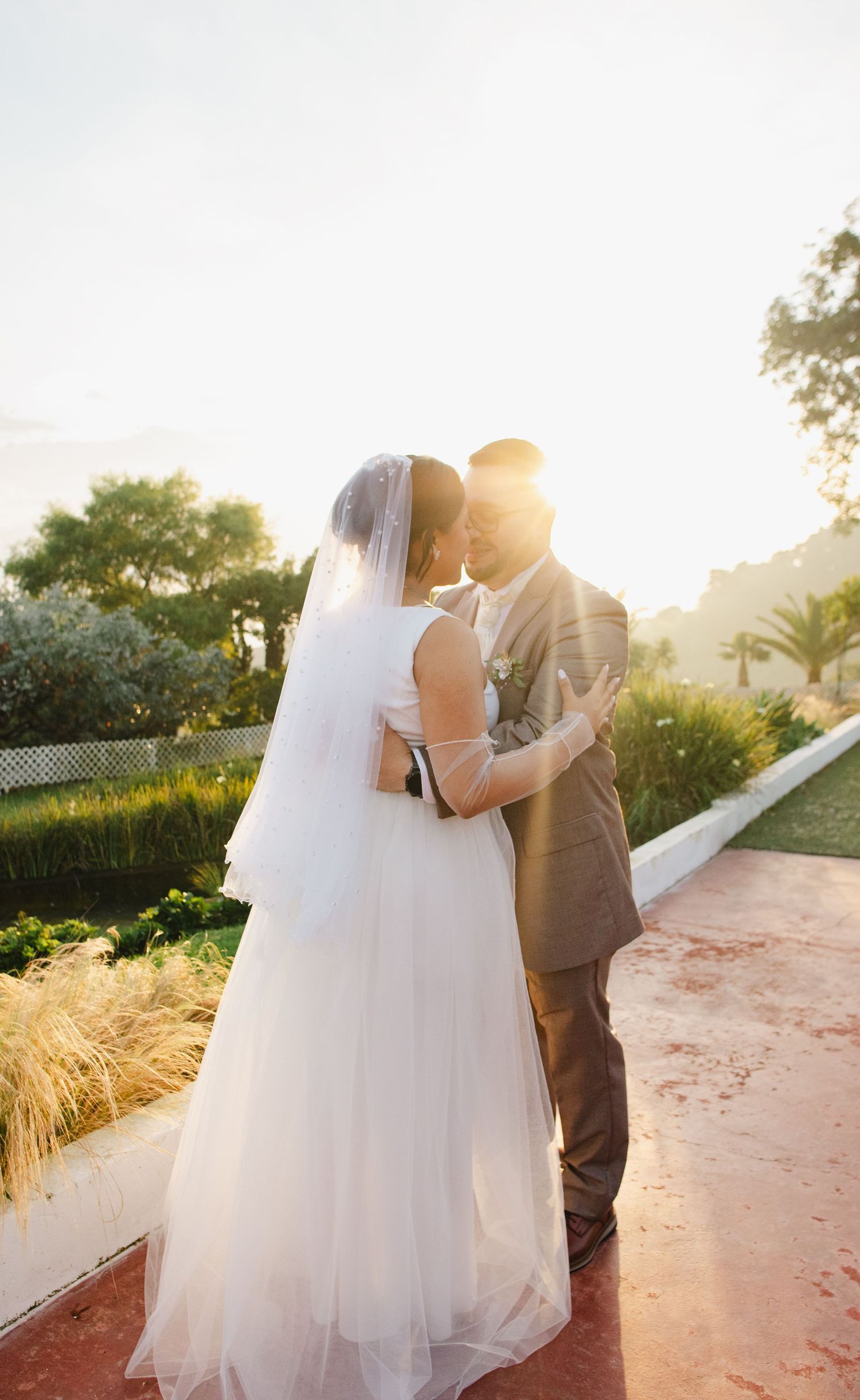 A romantic sunset wedding photo series shows a couple in formal attire embracing on a path with golden light.