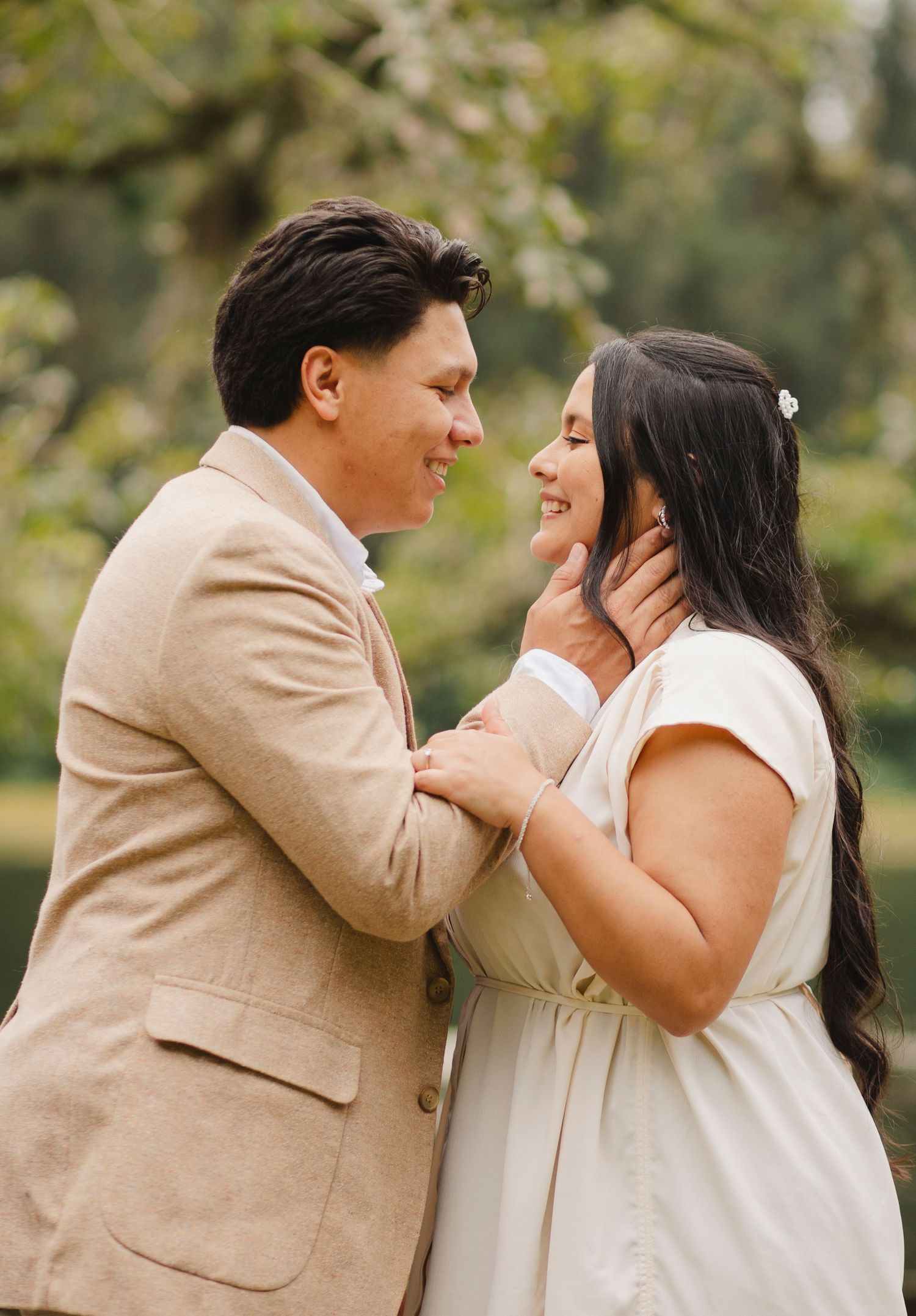 A romantic couple in beige and white attire share tender moments in a series of outdoor engagement photos.
