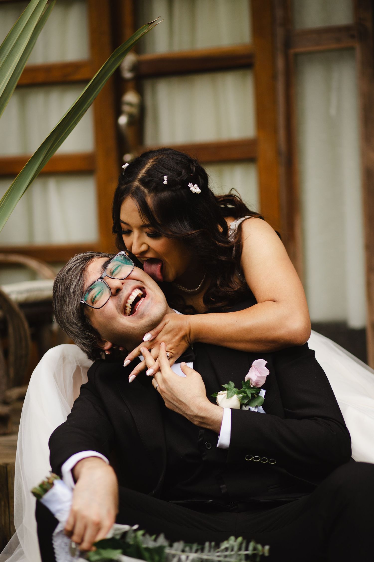 A joyful couple shares a candid laughing moment together during their wedding photoshoot.