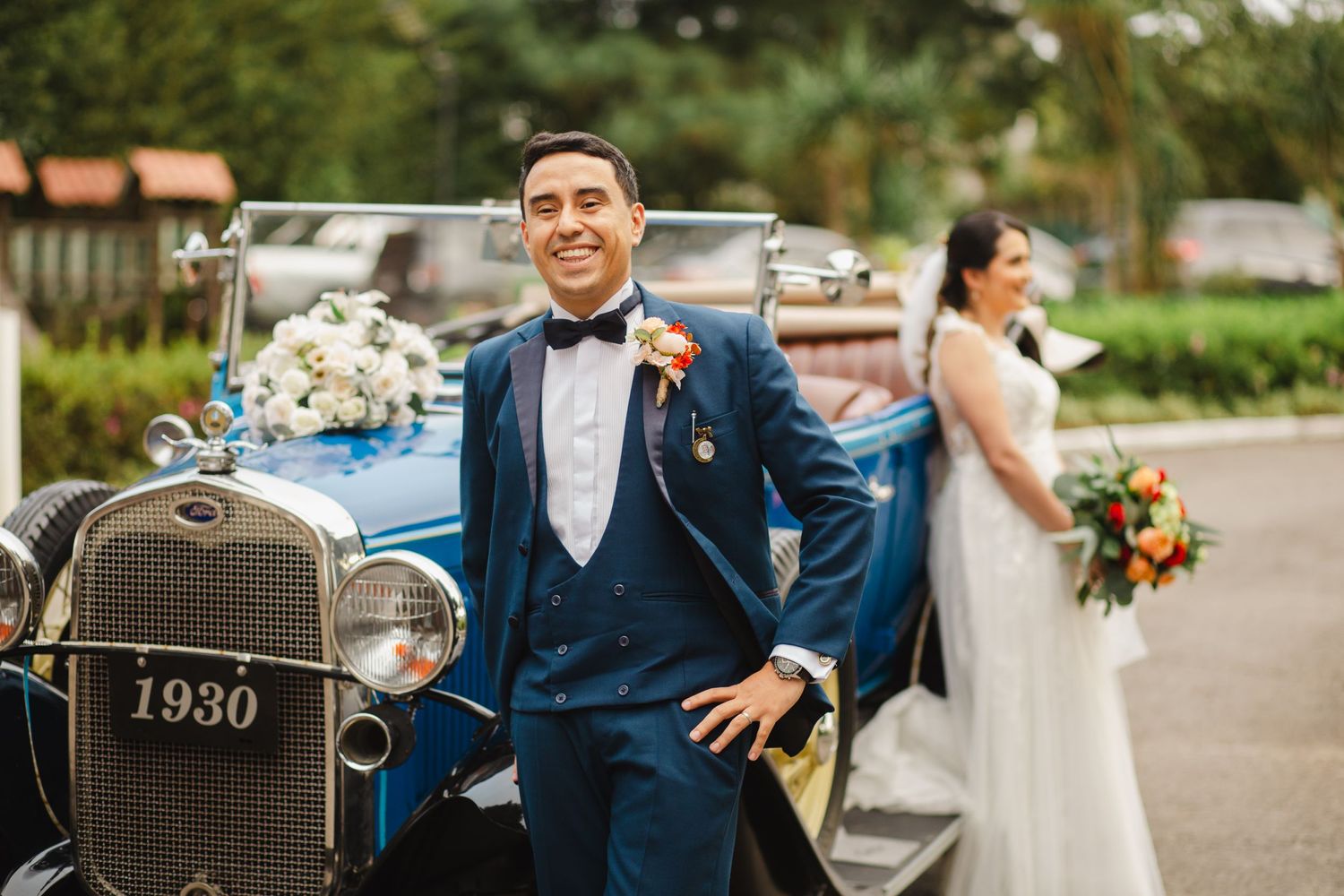 Wedding couple posing with vintage blue Ford car from 1930.