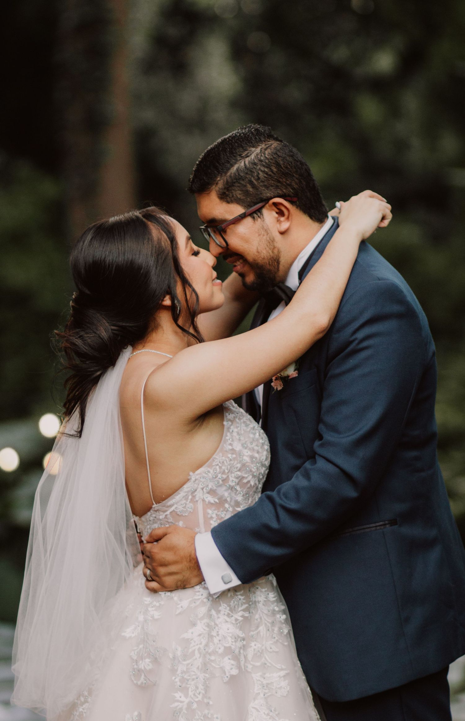 Couple in wedding attire sharing a joyful embrace outdoors.