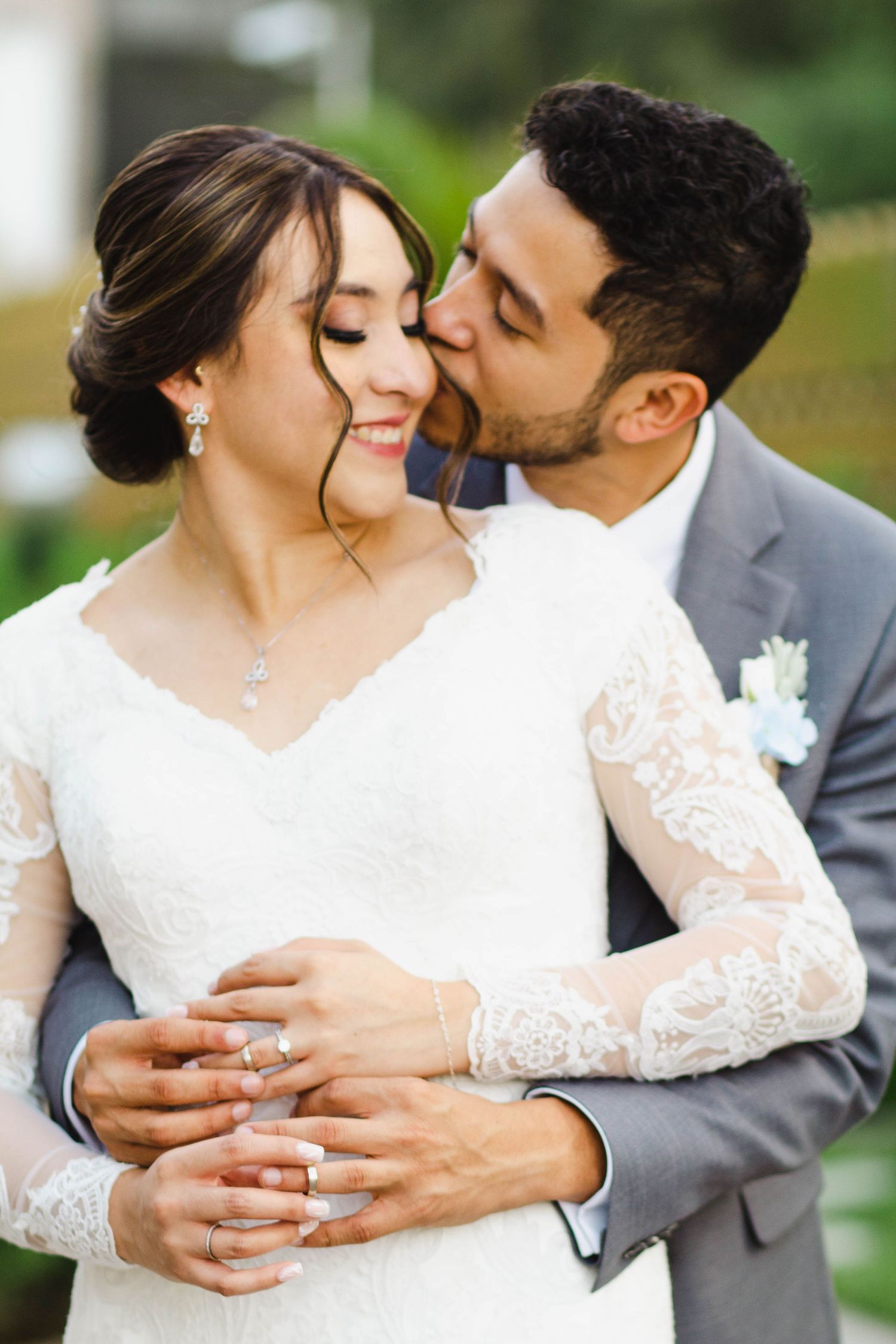 Intimate wedding portrait of couple embracing outdoors.