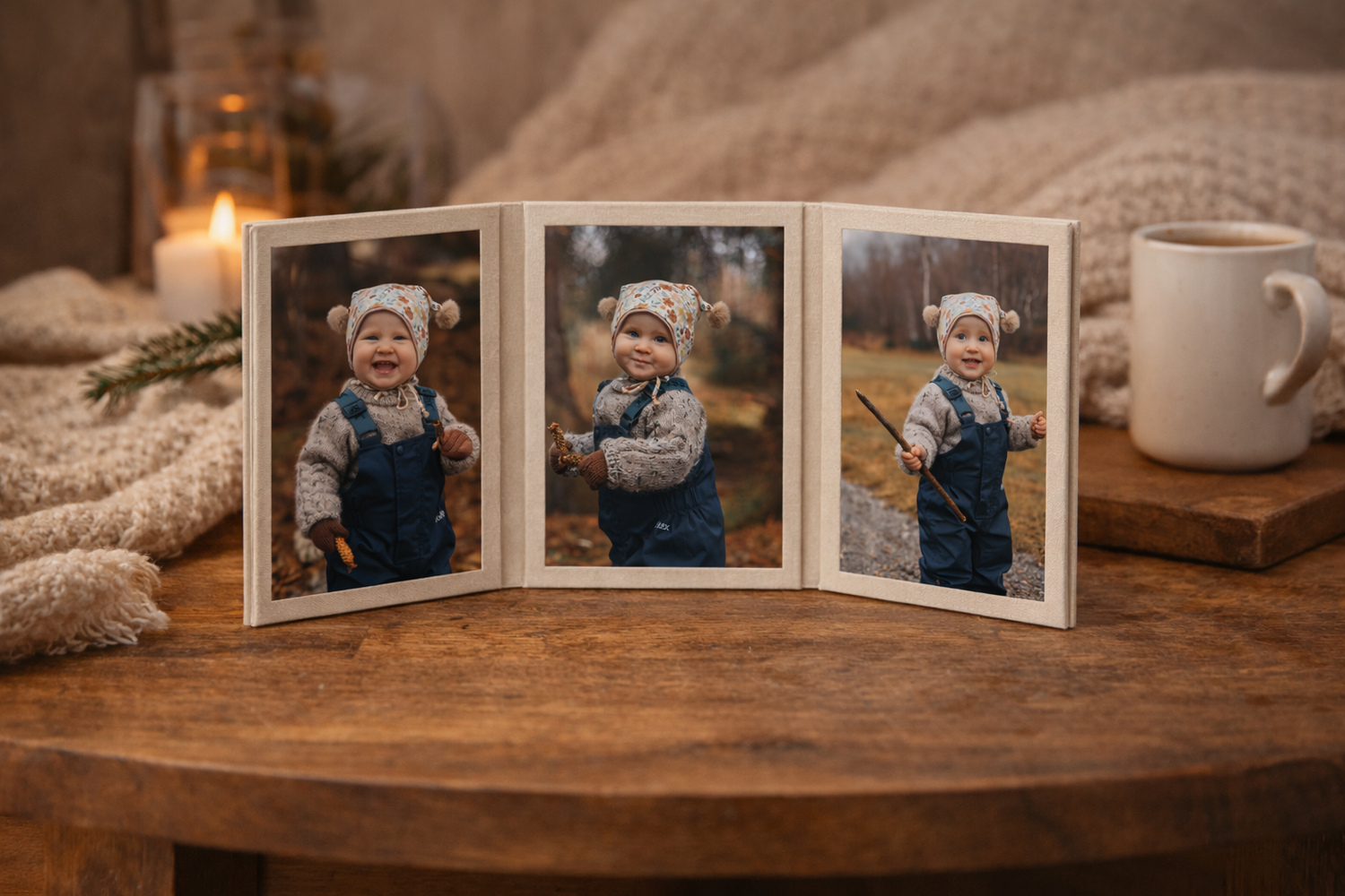 Triptych wooden photo display of a smiling toddler in winter clothes on a rustic table with candle.