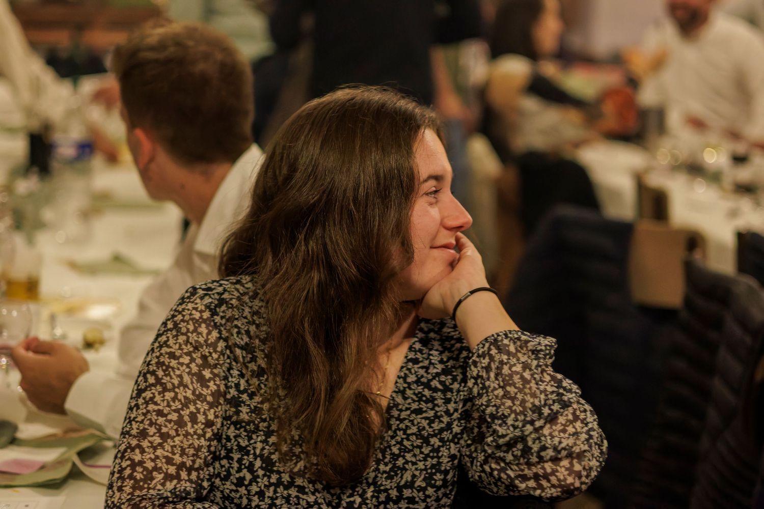 Une femme regarde pensivement avec un sourire