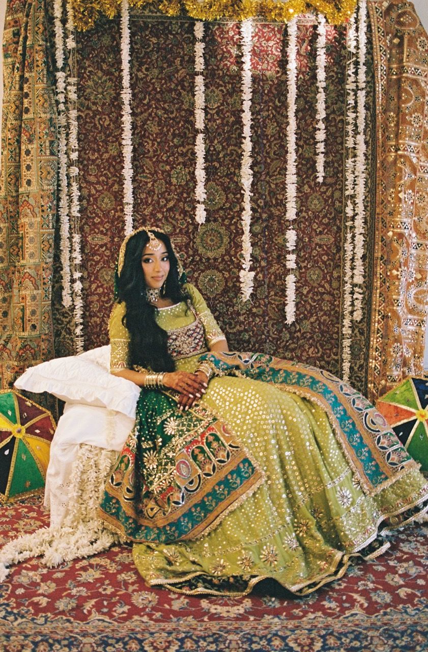 Bride posing in front of a Persian rug backdrop looking into the camera.