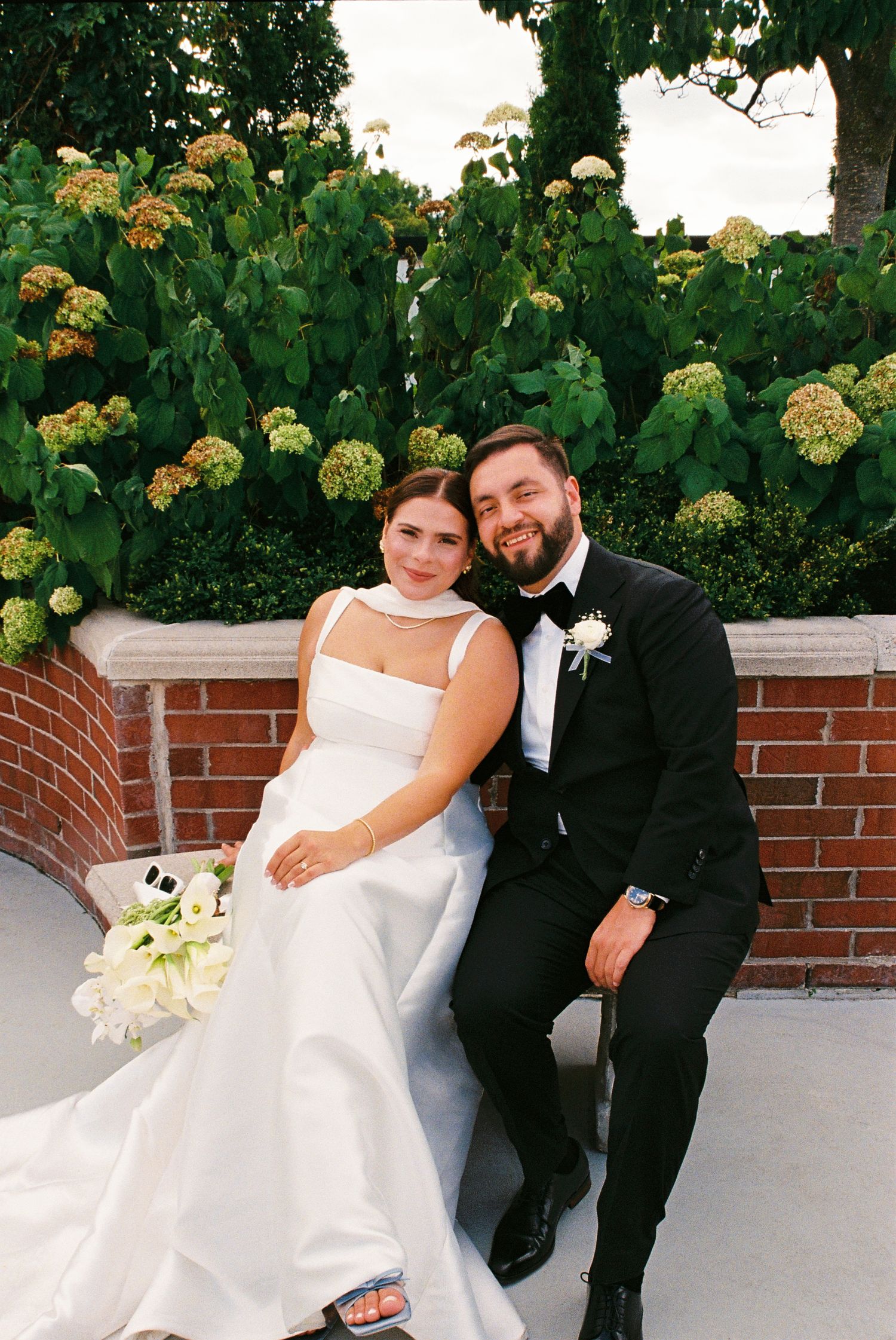Bride and groom sitting together before their reception on a rooftop garden at the Royal Venetian Mansion in Vaughan, Ontario.