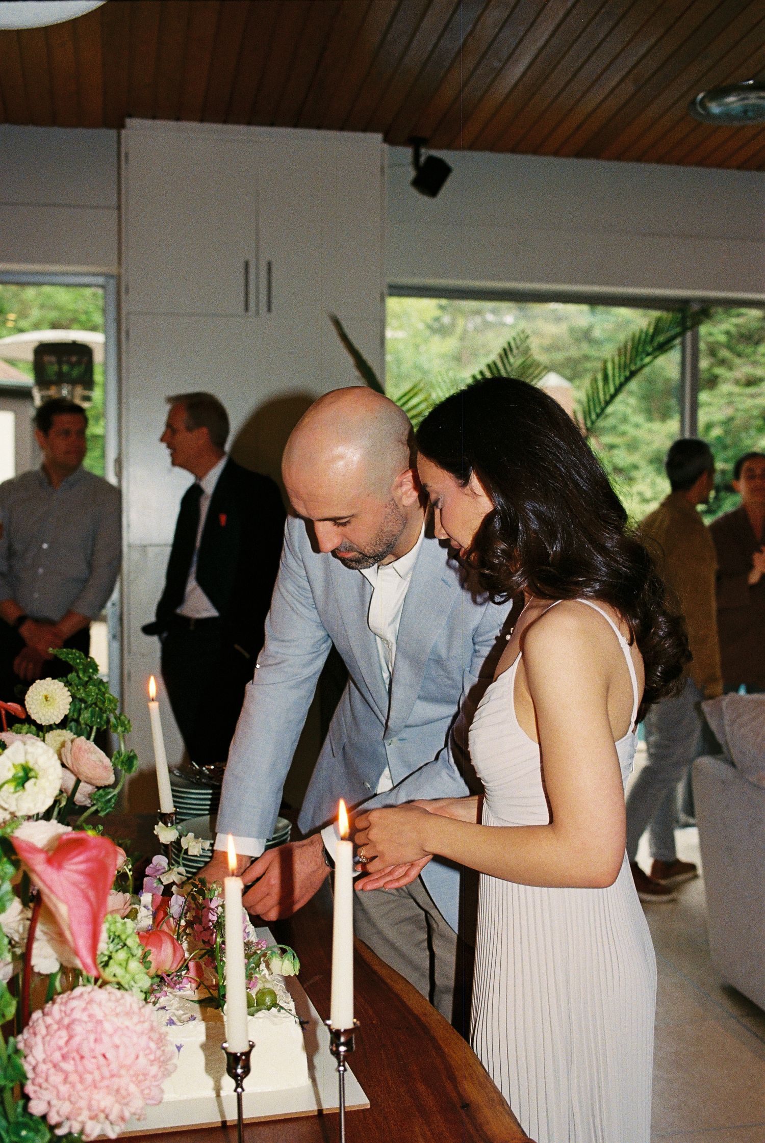 Fiancés cut their cake together at their engagement party.
