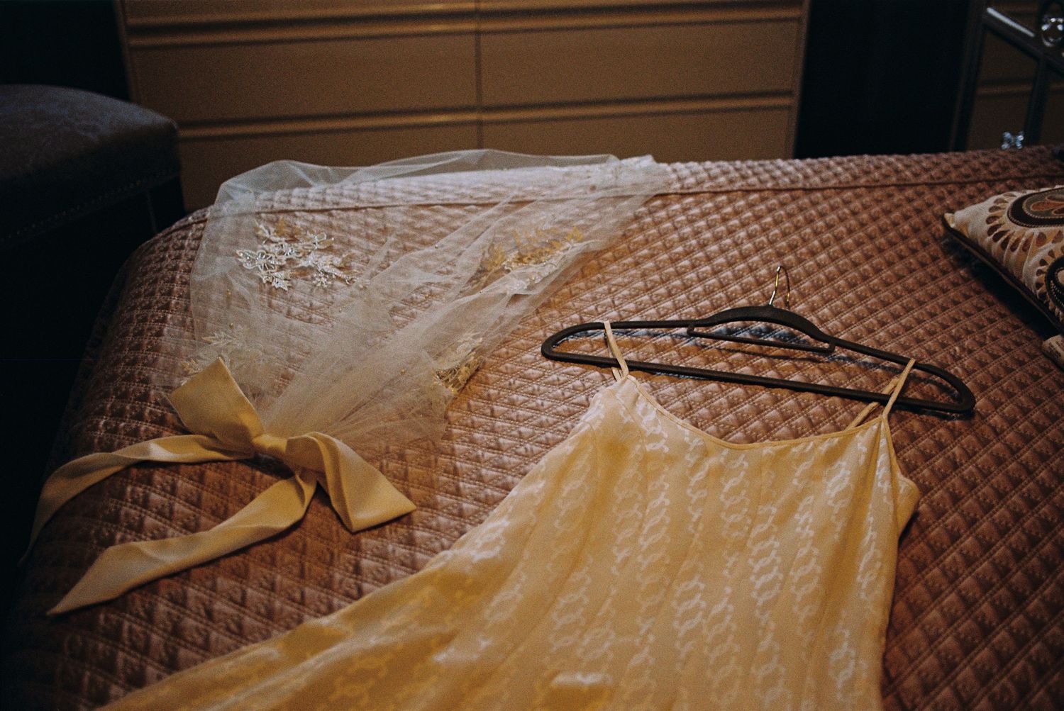 A bride's wedding dress and veil lay across the bed the morning of the wedding day.