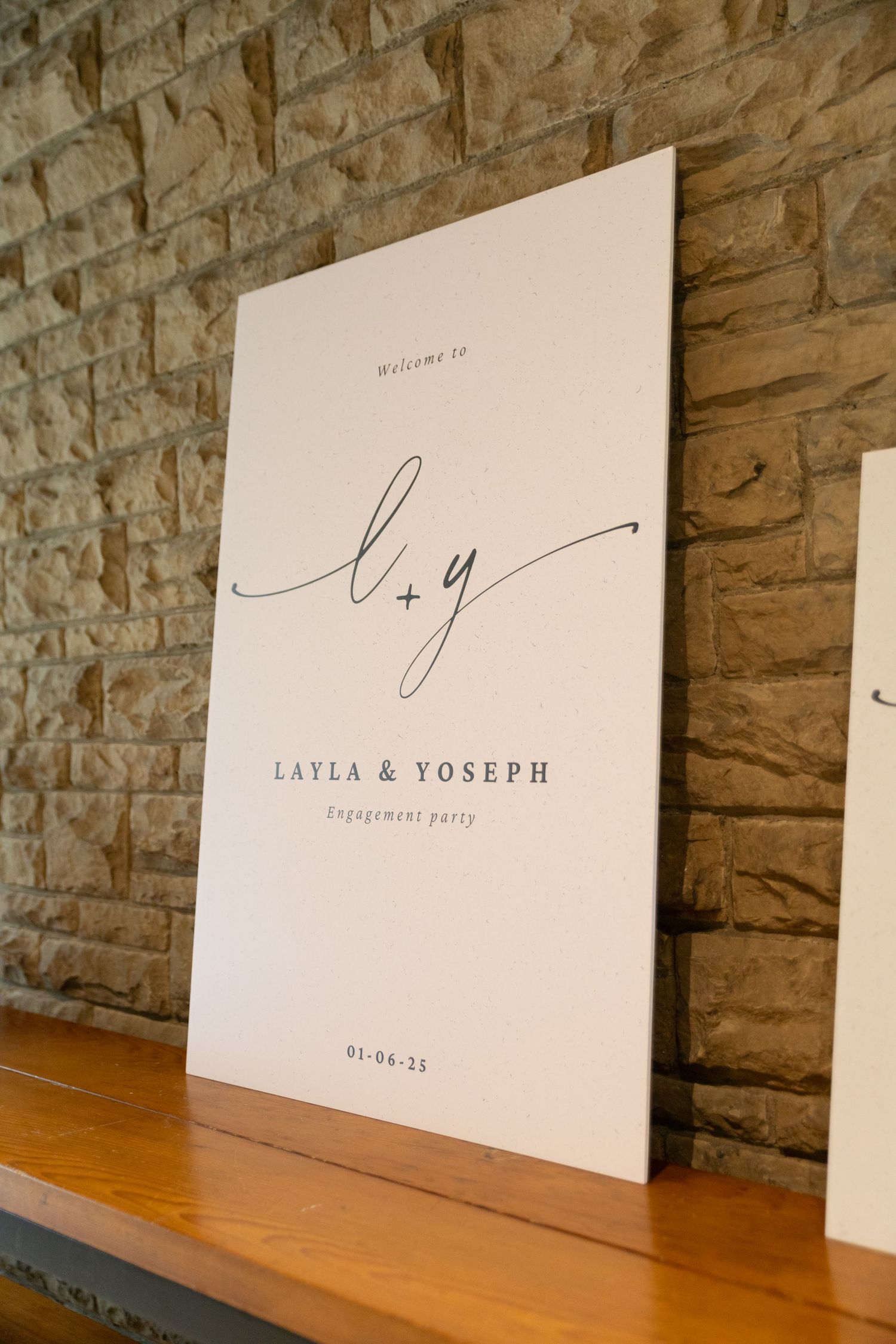 White engagement party signage with the couples names that welcomes guests.