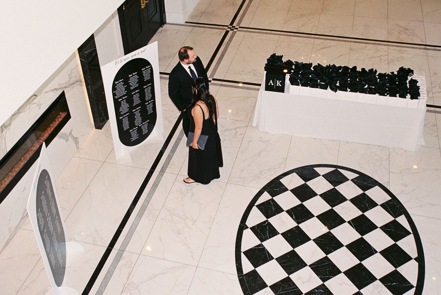 Groom and bridesmaid wait in the first floor of the reception for guests to arrive.