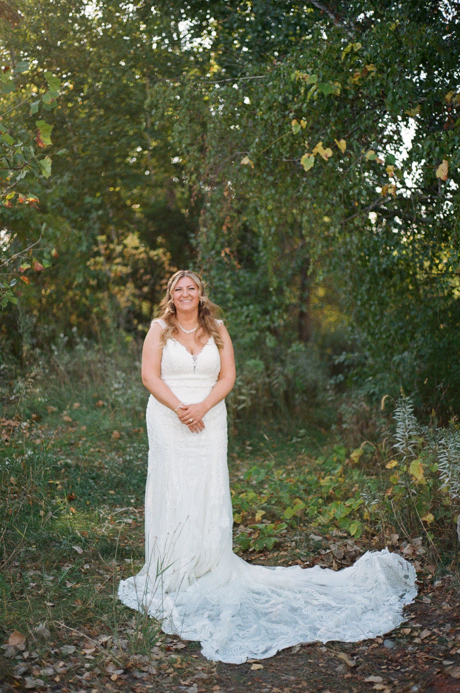 Film photo of bride posing in greenery.
