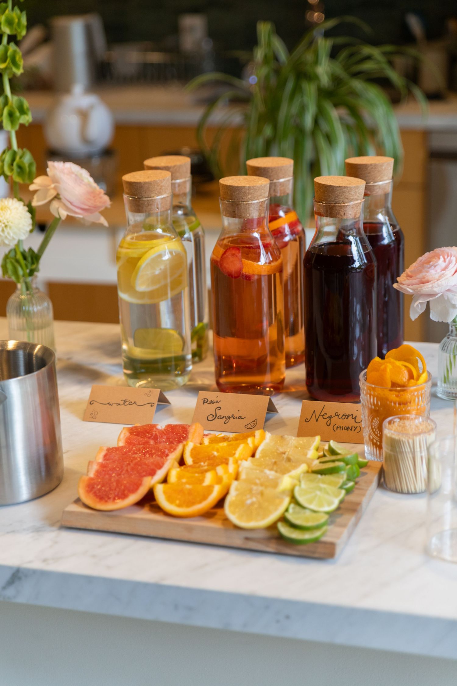 DIY mimosa bar with grapefruit, oranges, lemons, and limes at an engagement party.
