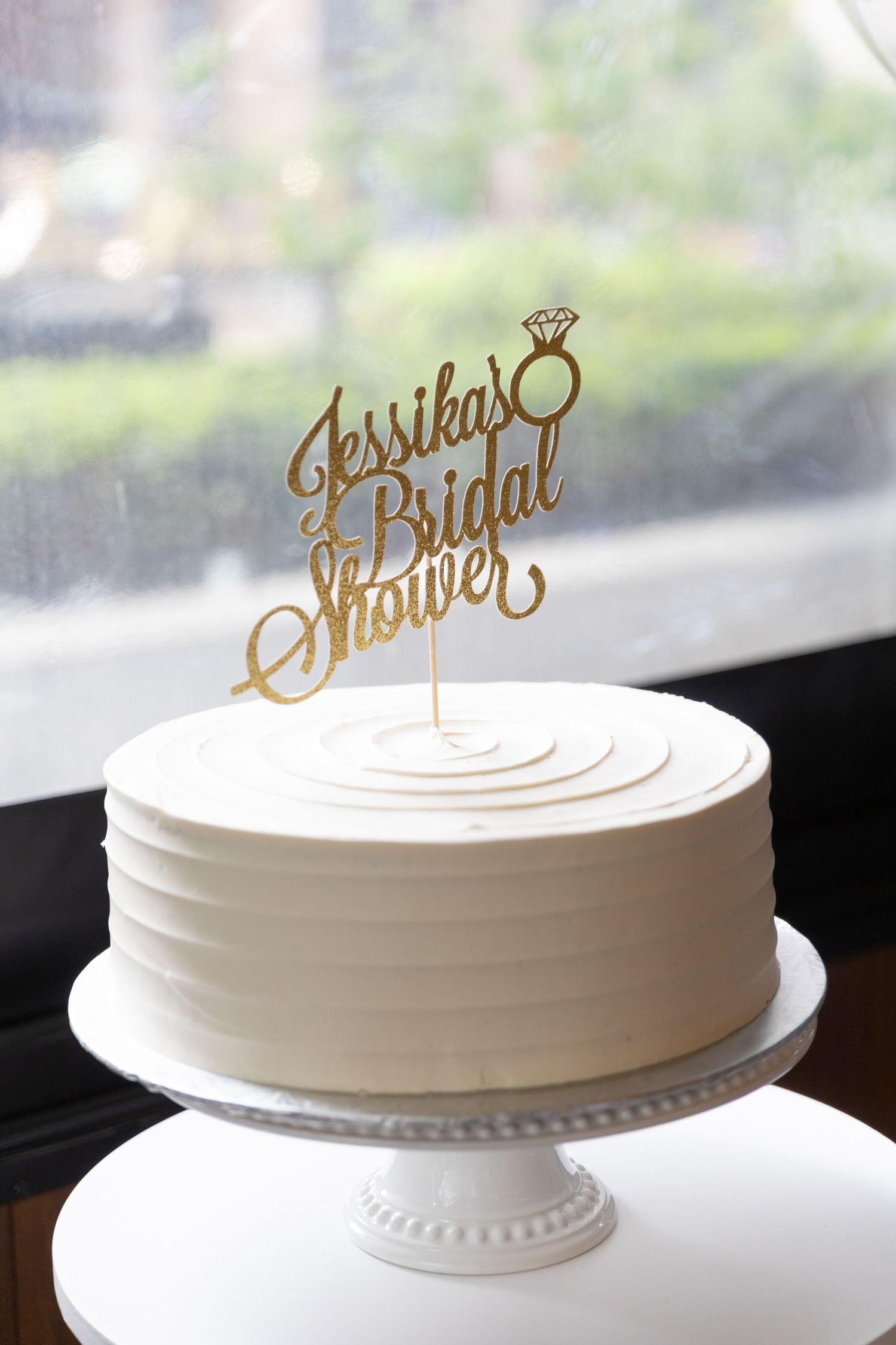 White bridal shower cake with a topper that reads 
