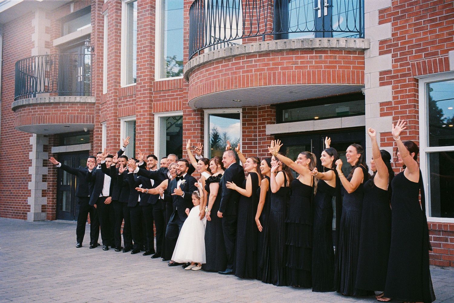 Bridal party, groomsmen, and family members standing together in front of the Royal Venetian Mansion in Vaughan, Ontario.
