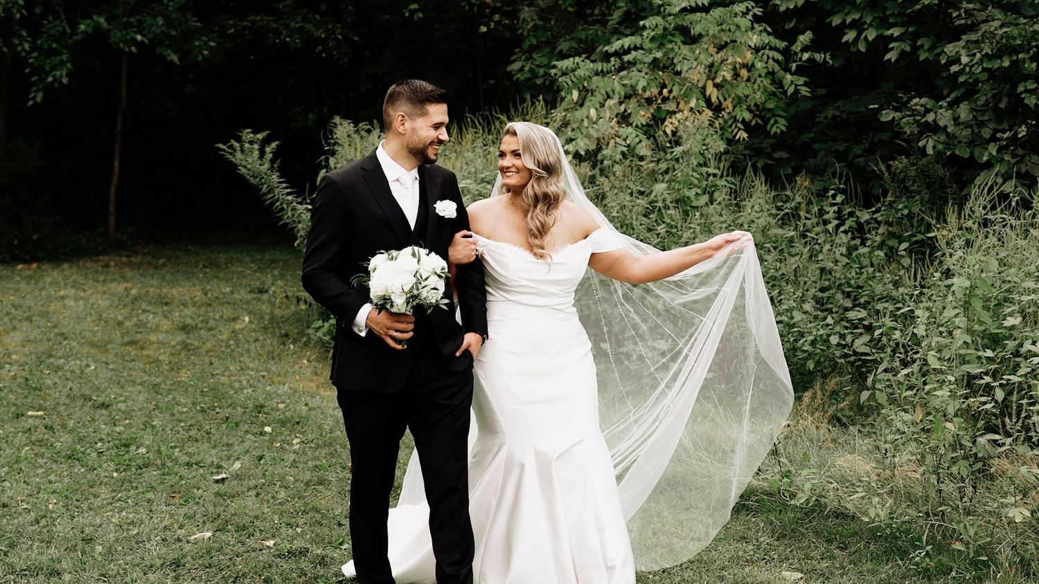Newlyweds sharing joyful moments in a lush garden setting.