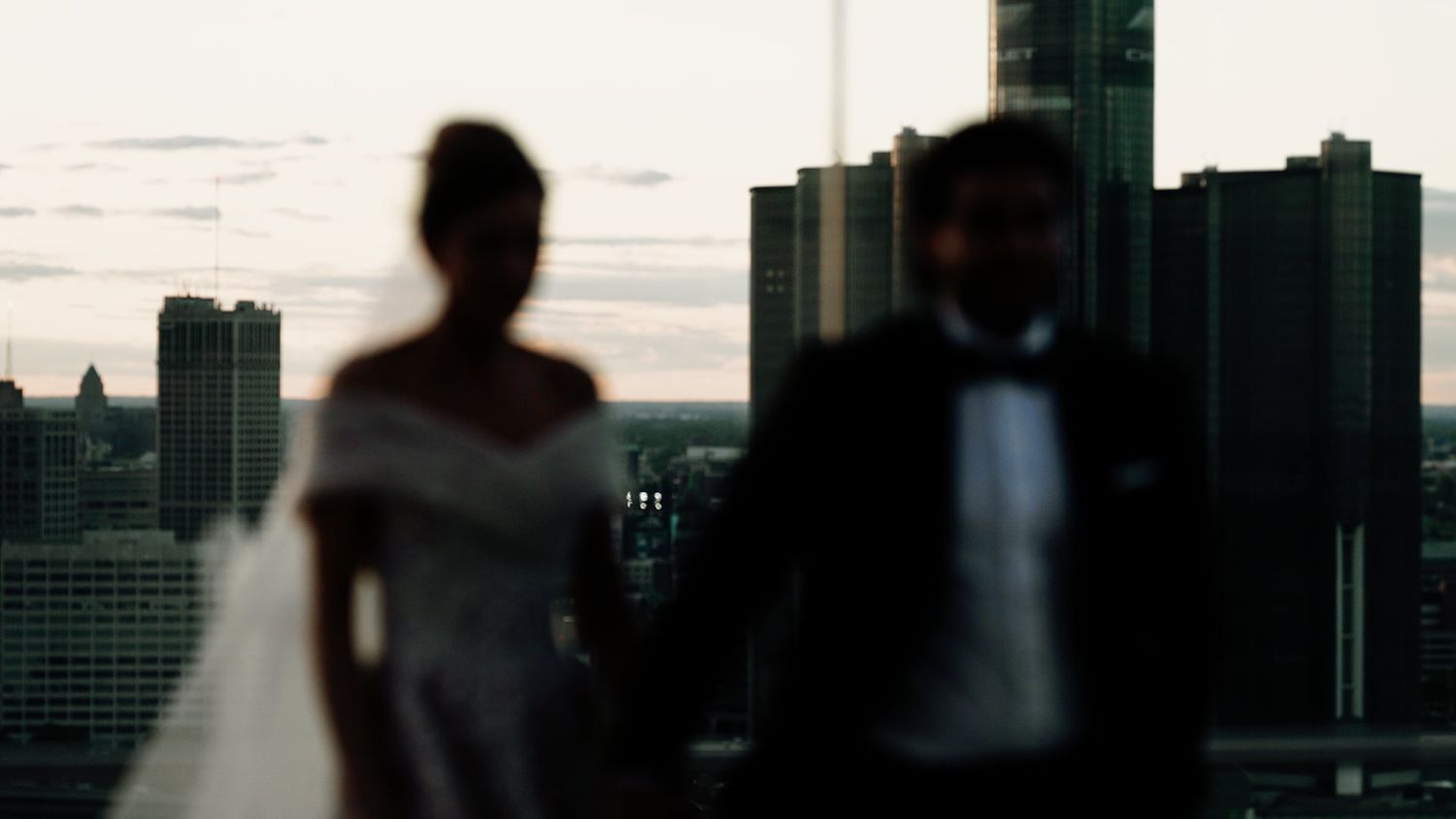 A silhouetted cityscape creates a dramatic backdrop for a romantic evening scene.