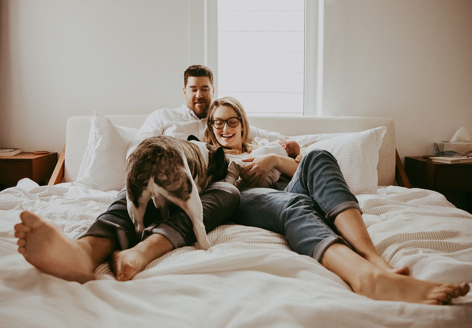 Intimate lifestyle photos of couple relaxing together on white bedding.