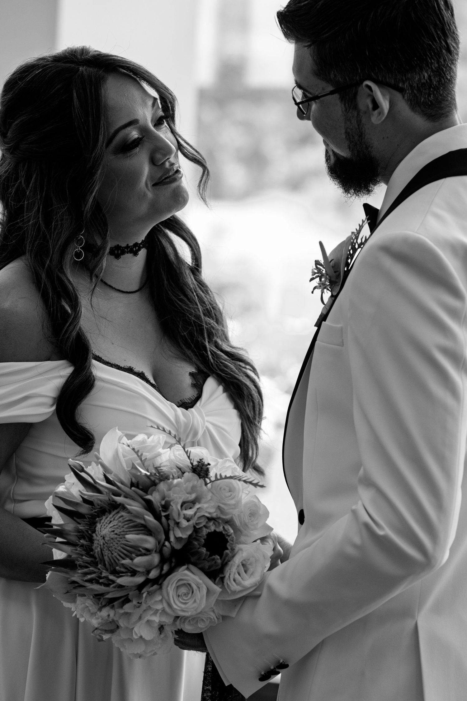 A romantic black and white photo series showing a couple embracing at their wedding with elegant floral bouquet details.